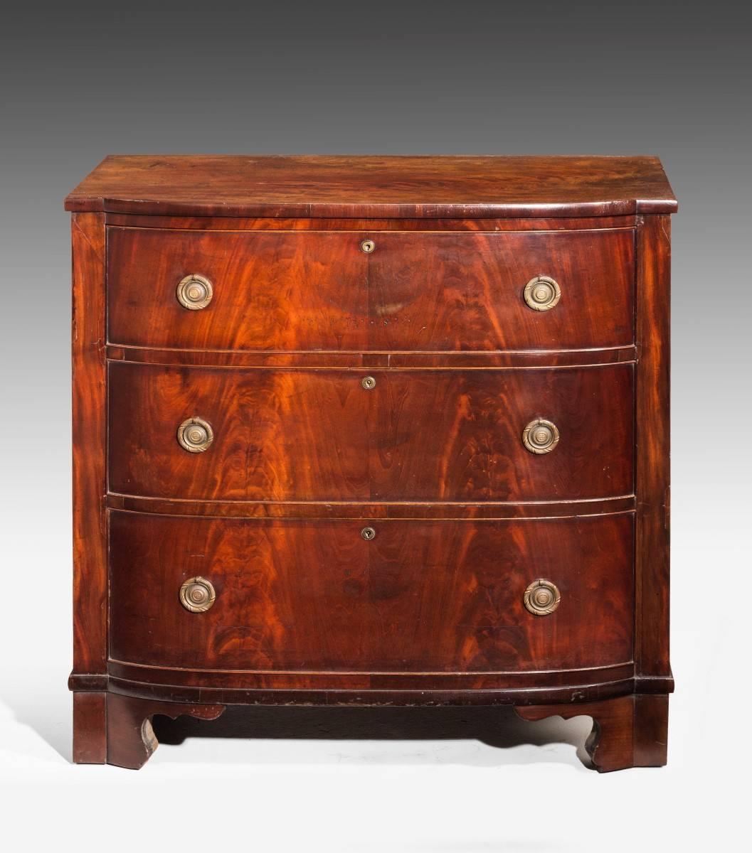 A most attractive Regency period bull-nosed D fronted mahogany chest of drawers. The very finely figured timbers leaf matched to left and right hand side. Excellent overall condition. Very well figured top which is somewhat patinated with age.