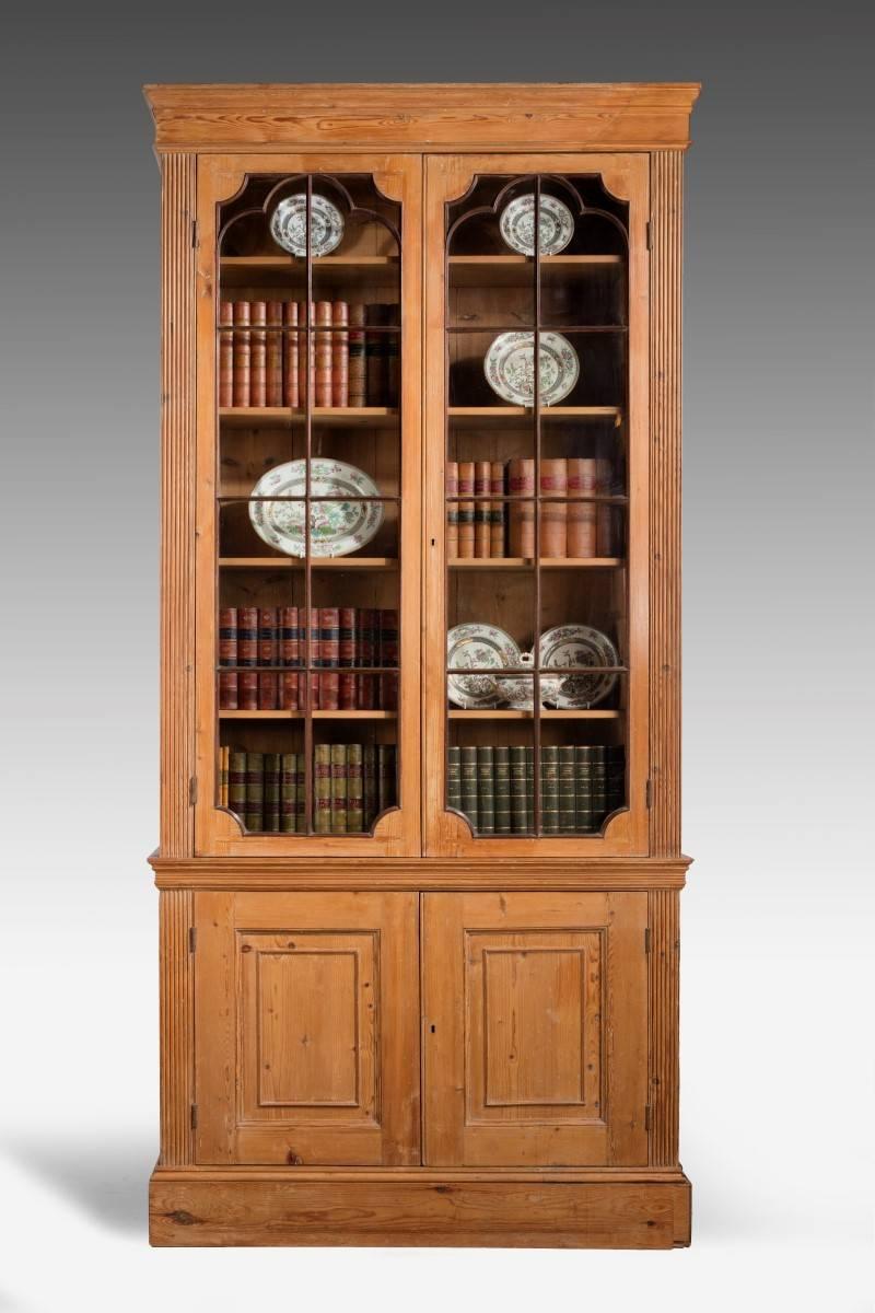 A good large George III pine bookcase. Retaining the original glazing bars and period glass. Reeded columns to the supports and panelled doors to the base section.