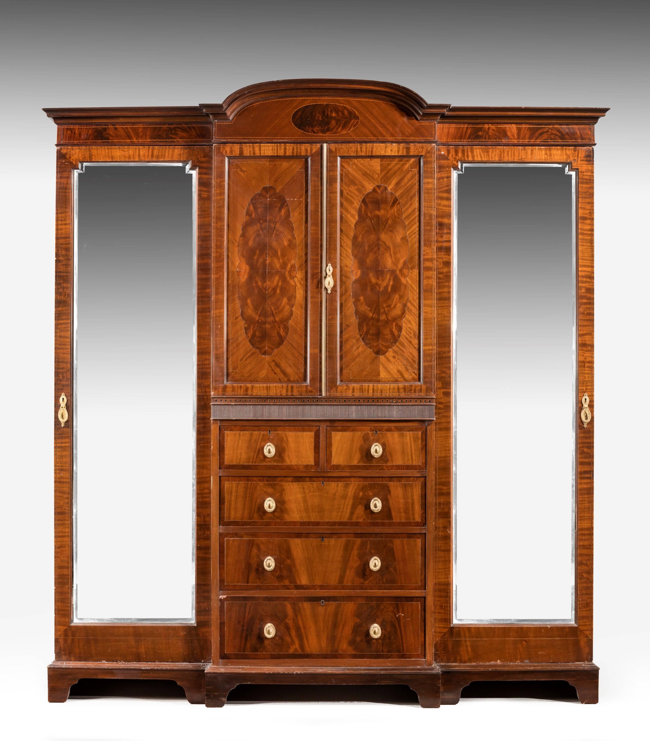 A good quality mahogany breakfront Wardrobe. With very finely figured contrasting quartered panels to the upper doors. Retaining original oval cast gilt bronze handles.
