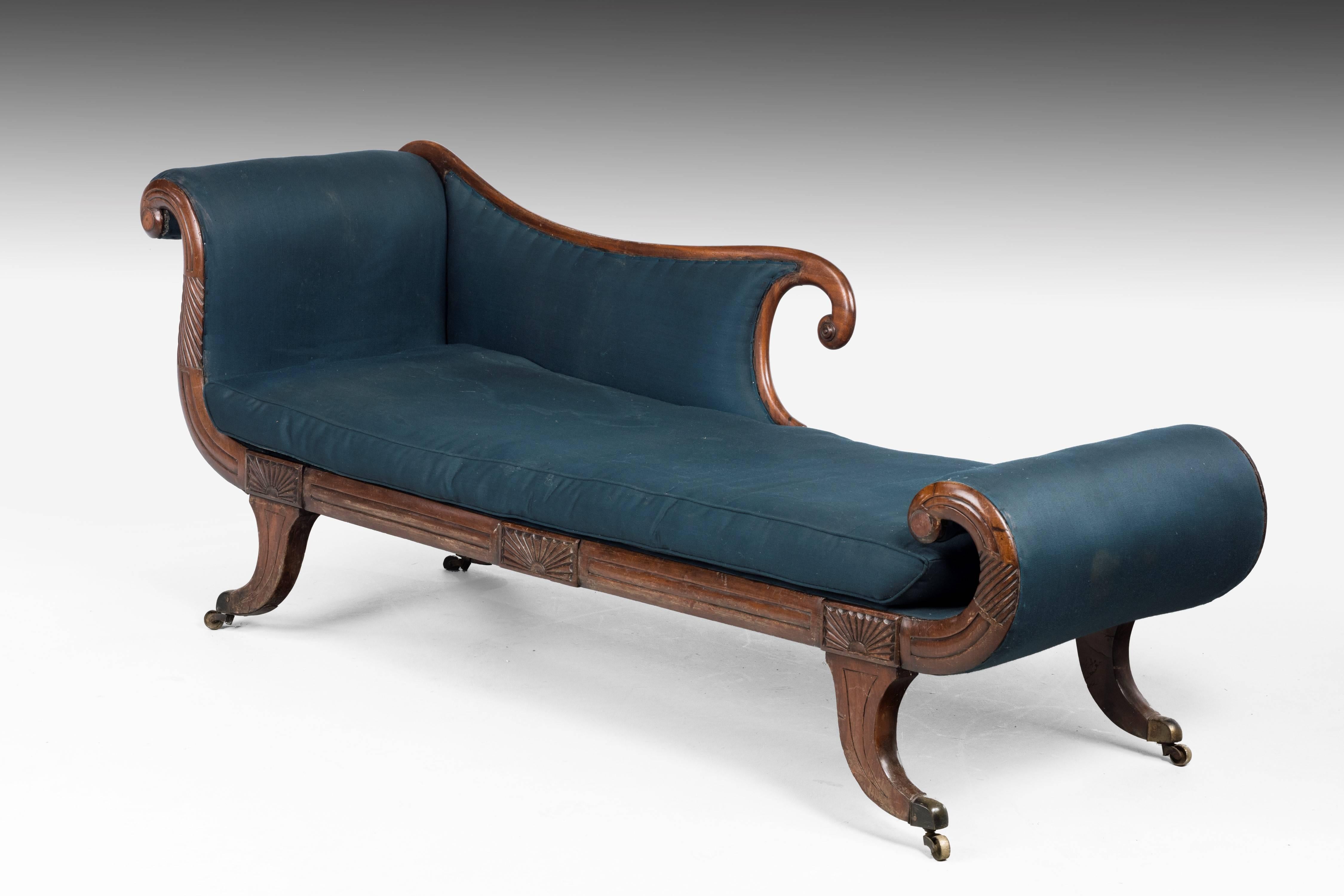 An attractive Regency period Chaise Lounge. On well shaped sabre supports with sun burst carving to the upright sections. Elegant overall lines. The timbers and brass all being original.