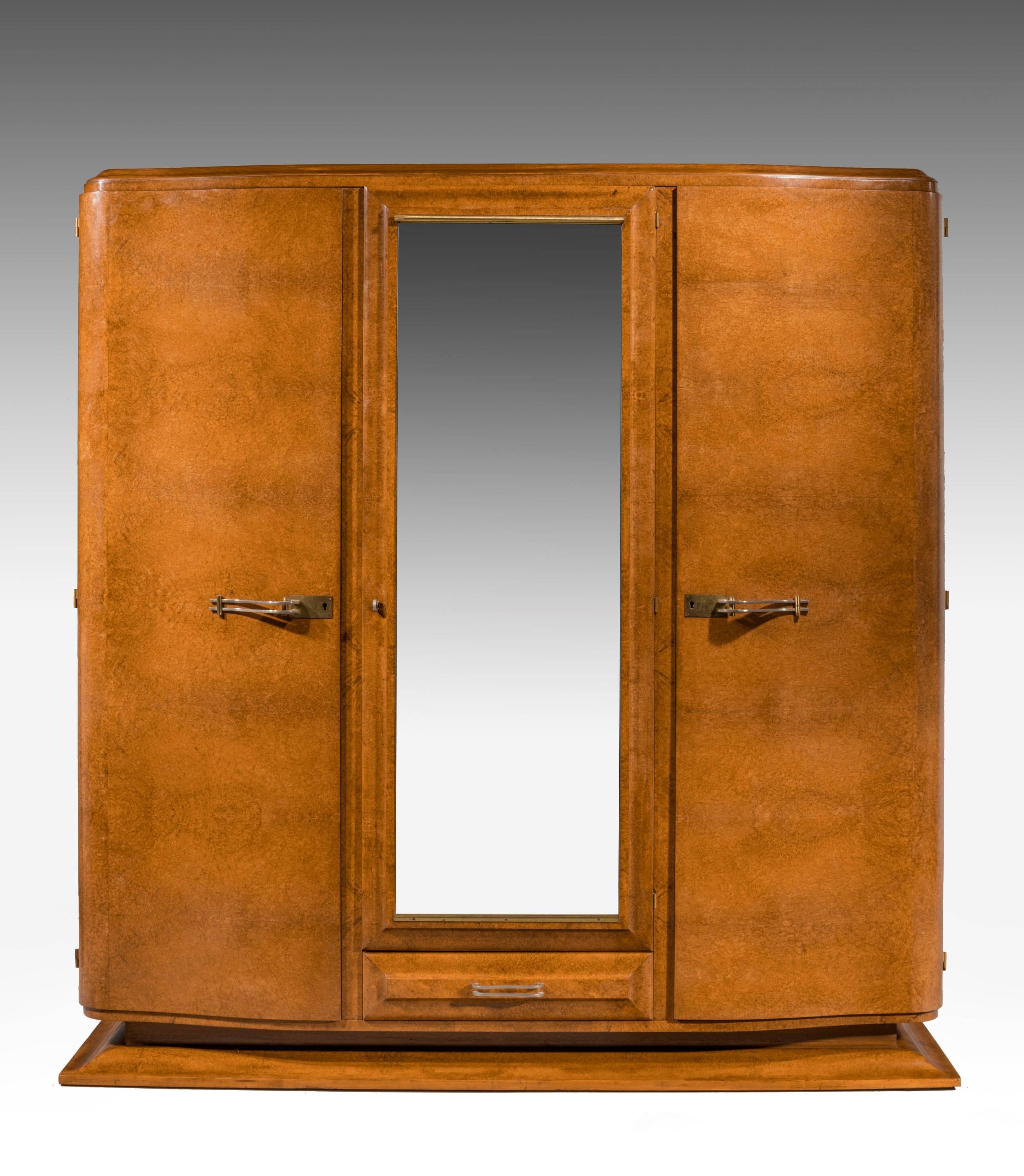 A quite exceptionally fine Art Deco birchwood wardrobe of complex construction. With beautifully highly figured timbers, with an interior lined with a pale blonde wood. With a number of options of positions for the shelves. The whole of quite