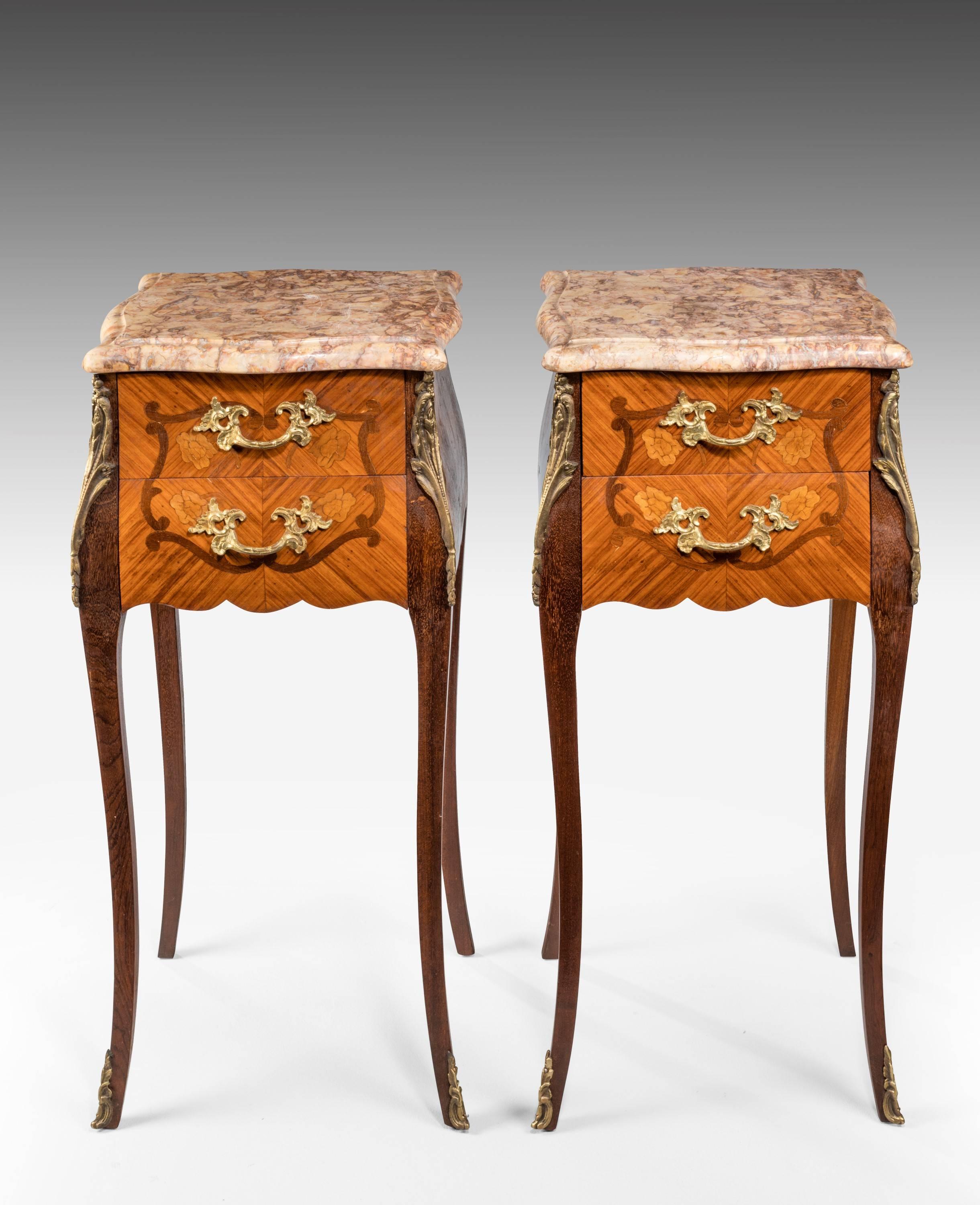 A most attractive pair of kingwood and marquetry petit commodes on cabriole supports. Retaining the original gilt bronze mounts. Well figured marble tops. Each with two drawers.