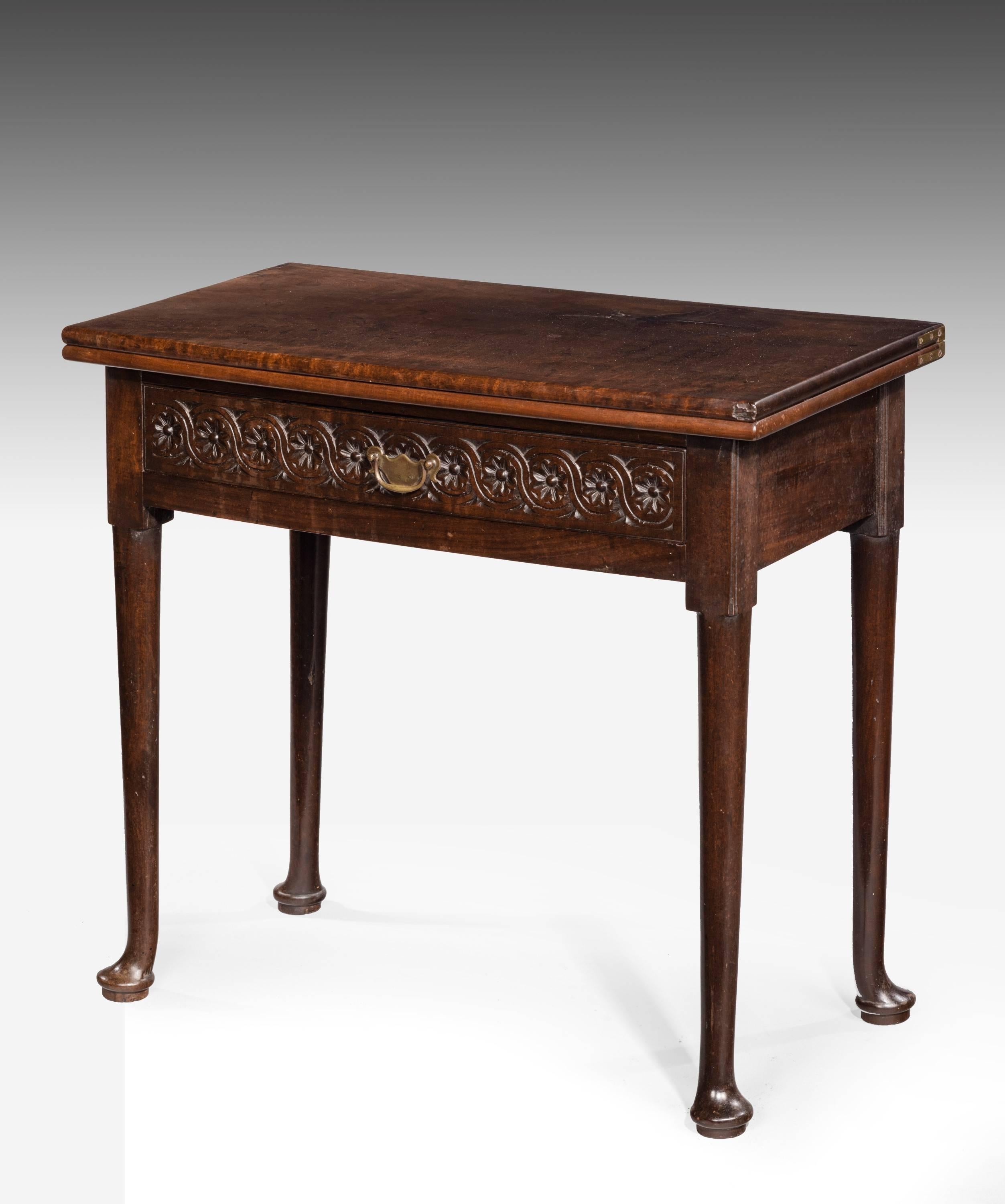 A small mid-18th century mahogany tea table. On gentle cabriole supports. The single drawer front with continuous carved frieze. Very good overall color and patina.