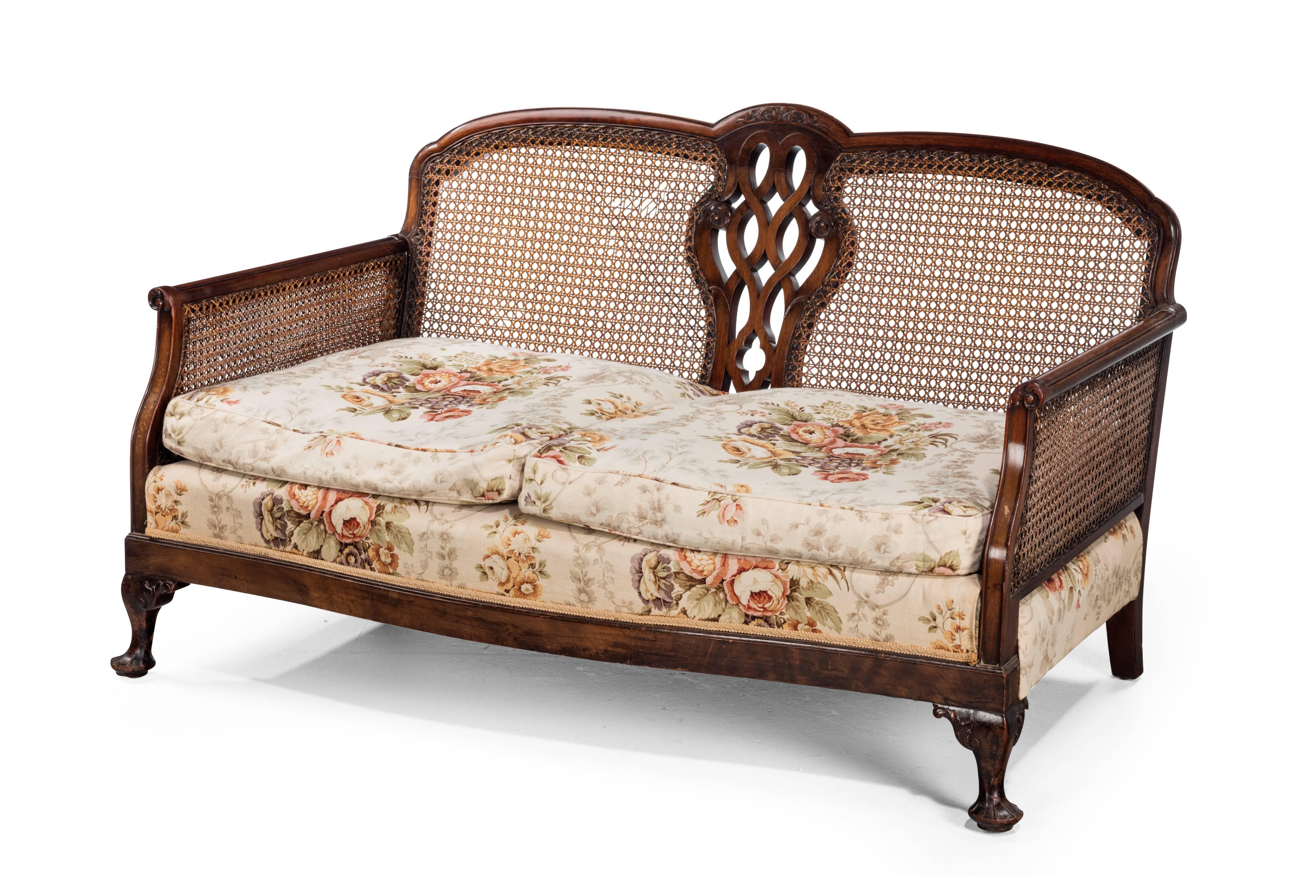 A mahogany framed bergere sofa of small proportions. With good quality original cane work to the sides and back.