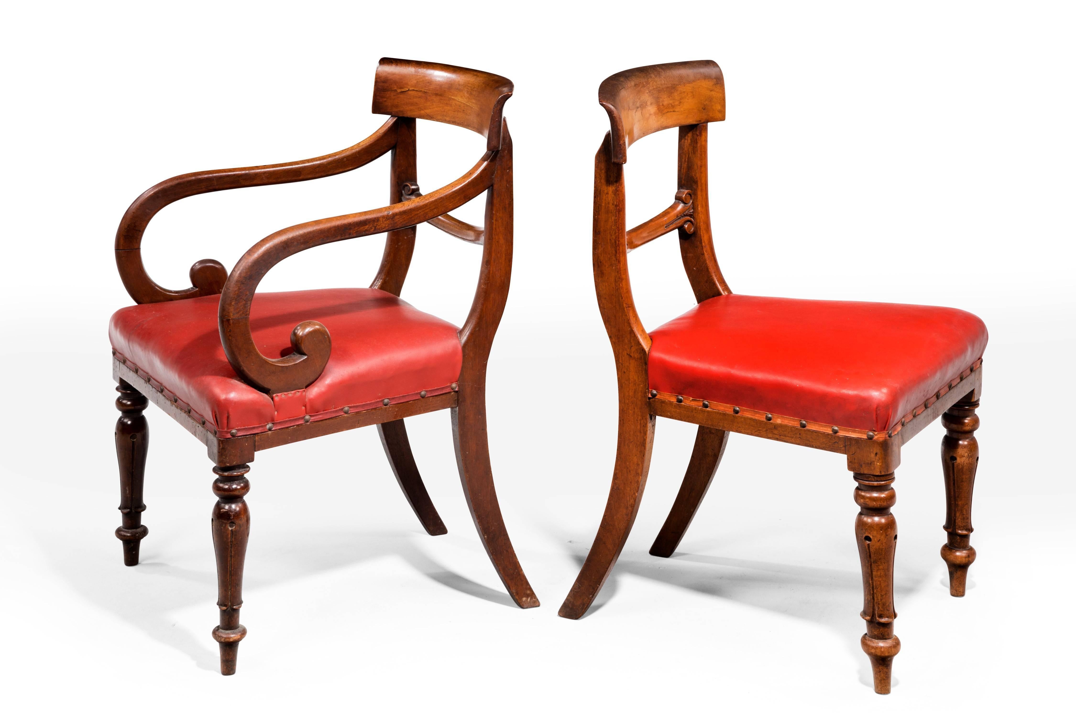 A good and original set of seven Regency period mahogany framed chairs. The arms continuously reeded. On tapering turned supports. The back central splat finely carved with scrolls.