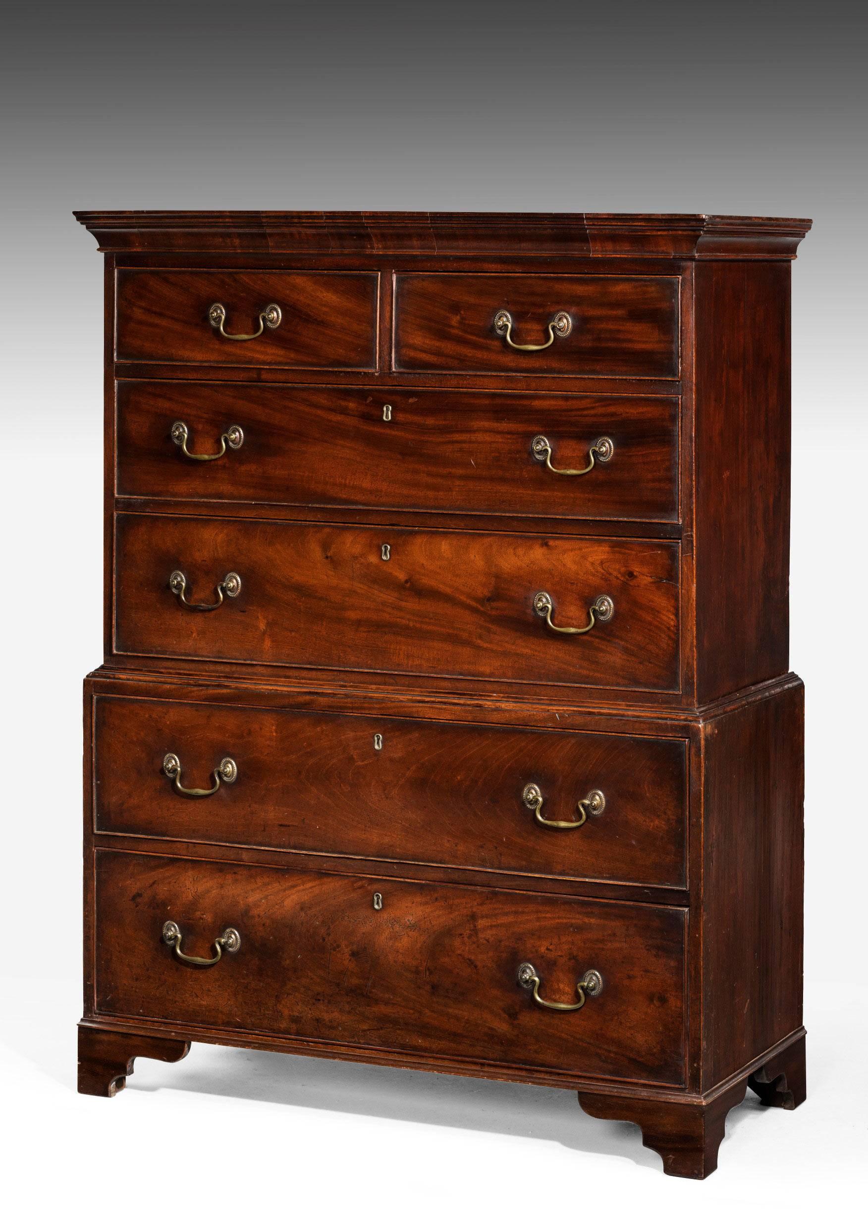 Unusually slender George III period mahogany chest on chest of very small proportions. Fine quality original bronze swan neck handles. Original bracket feet.