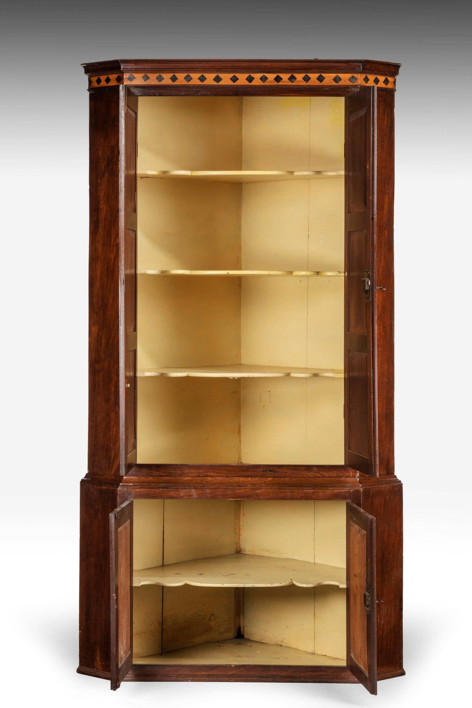 An attractive George III period mahogany double corner cupboard. The interior retaining the original and most attractive double serpentine shelves.