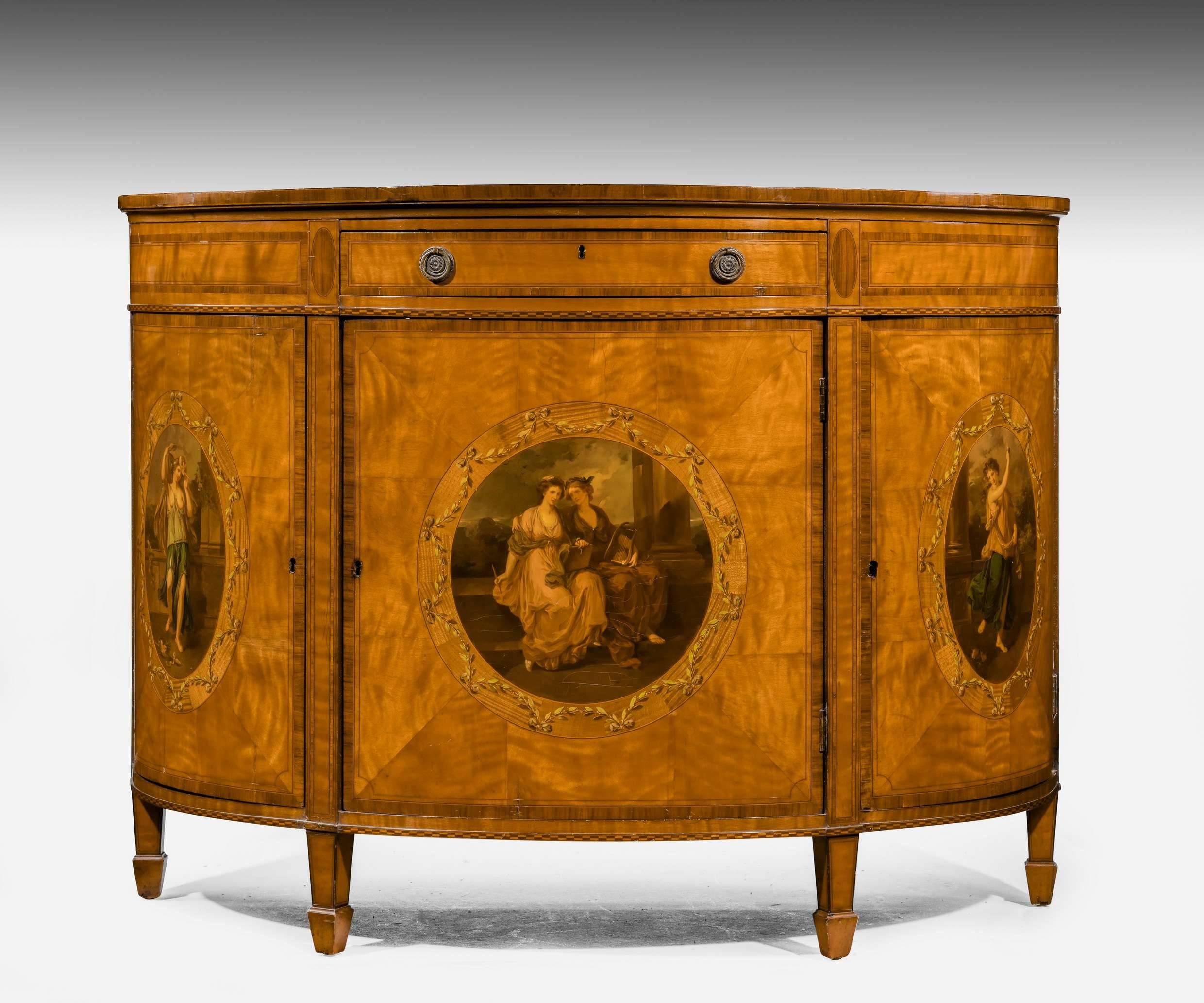 A quite outstanding satinwood demilune commode. The three cupboard bases with the most extraordinary finely painted decoration in the manor of Kauffman. The top with a half shell decoration to the back. Crossbanded, banded and edged in contrasting