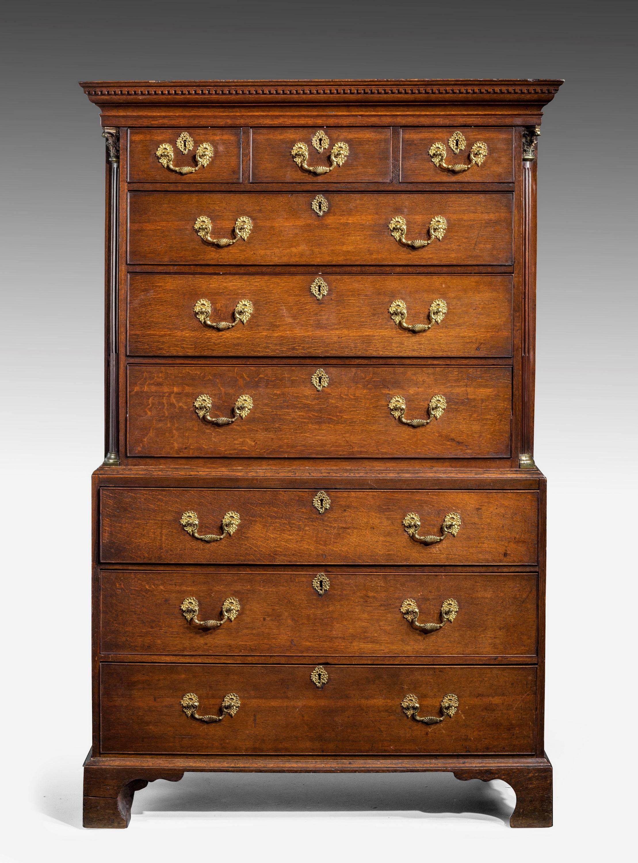 A George III period oak chest on chest. The moulded cornice over three short and three long drawers to the base. Quartered columns with gilt capitals to the corners and original bracket feet.