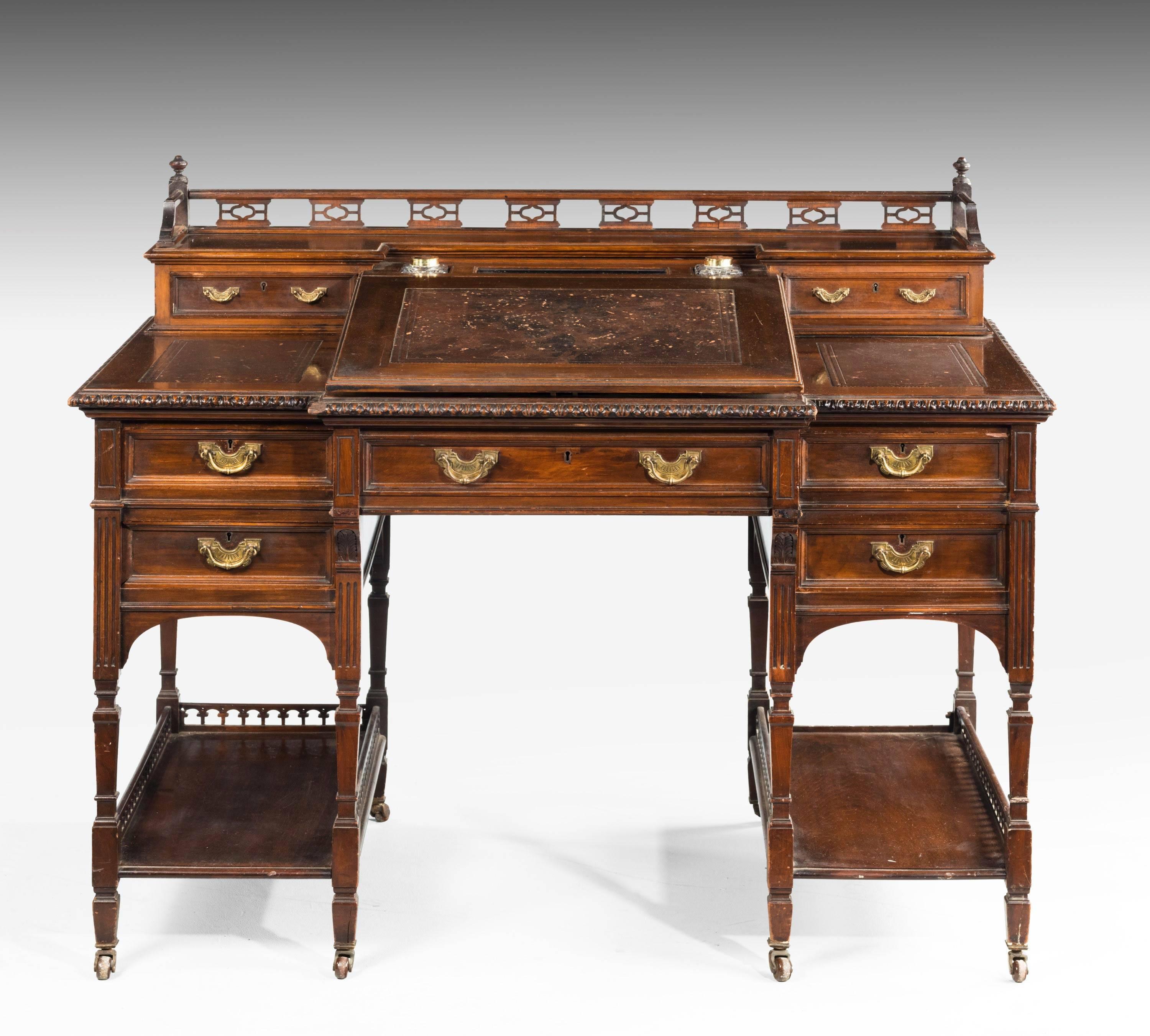 A good late 19th century mahogany desk with a well pierced gallery with fitted inkwells to the upper section. The lifting slope interior with fitted birch drawers and Pidgeon holes.