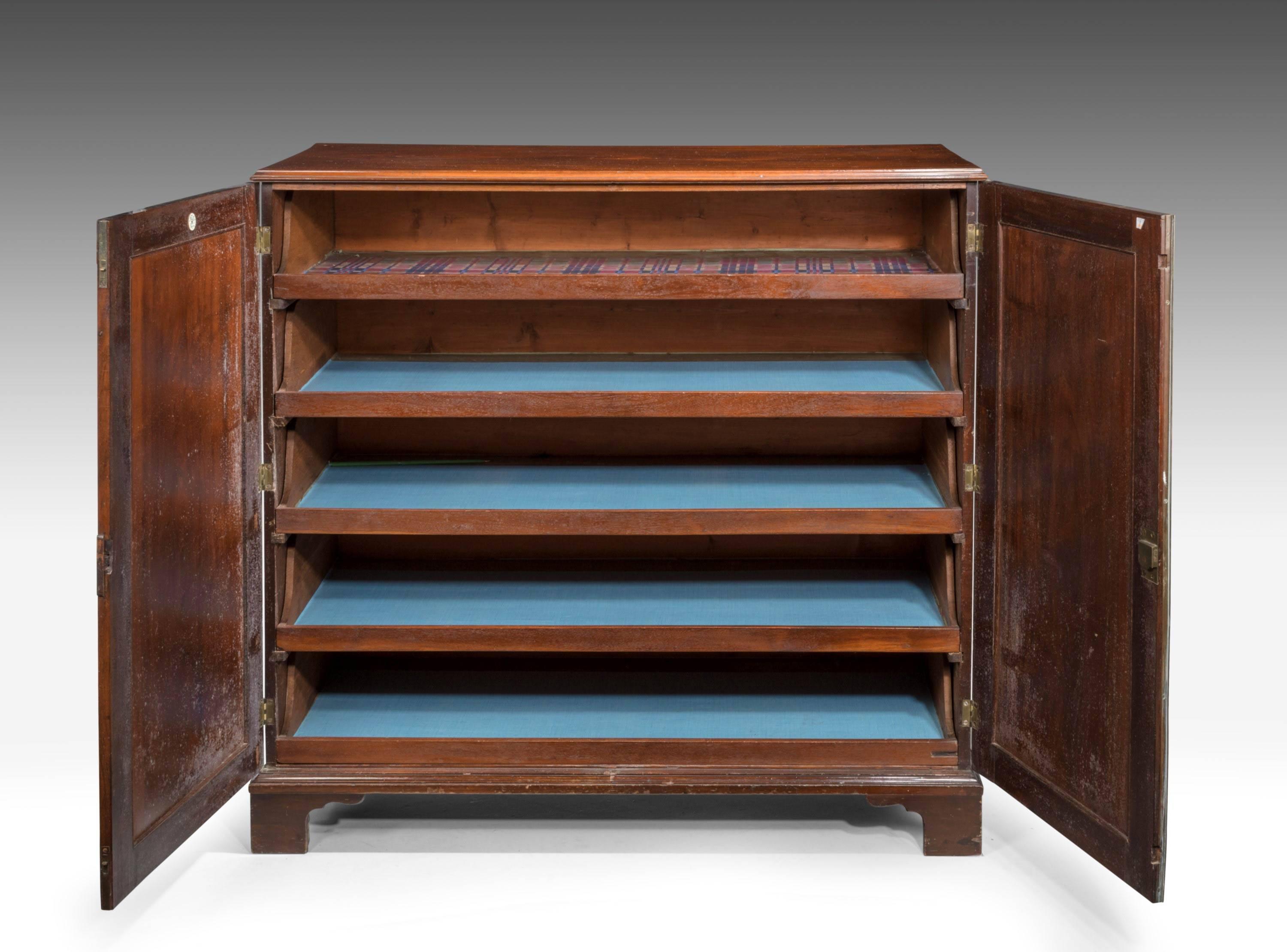 A particularly handsome George III period mahogany dwarf press. The interior with the original fitted shelves. The beautifully figured flamed oval panels to the doors, surrounded with crossbanded borders and satinwood extremes.