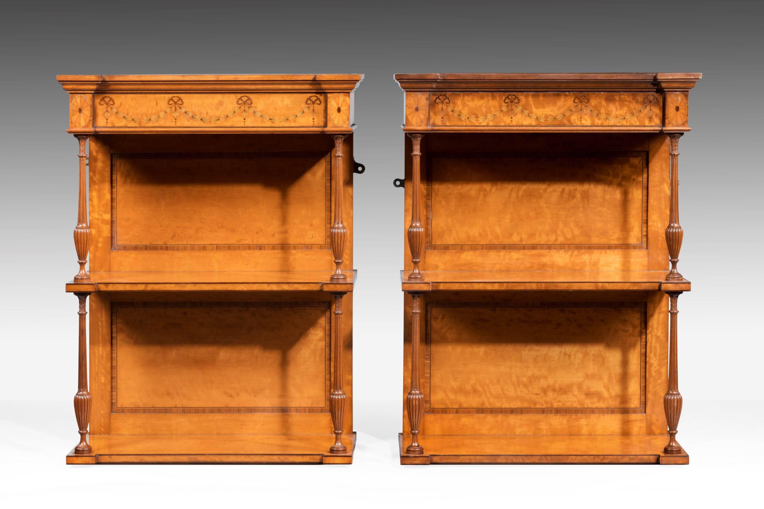 A rare pair of beautifully figured satinwood and marquetry hanging shelves. Finely crossbanded detail and marquetry inlay to the top section. Finely turned pear shaped supports to the reeded decoration.