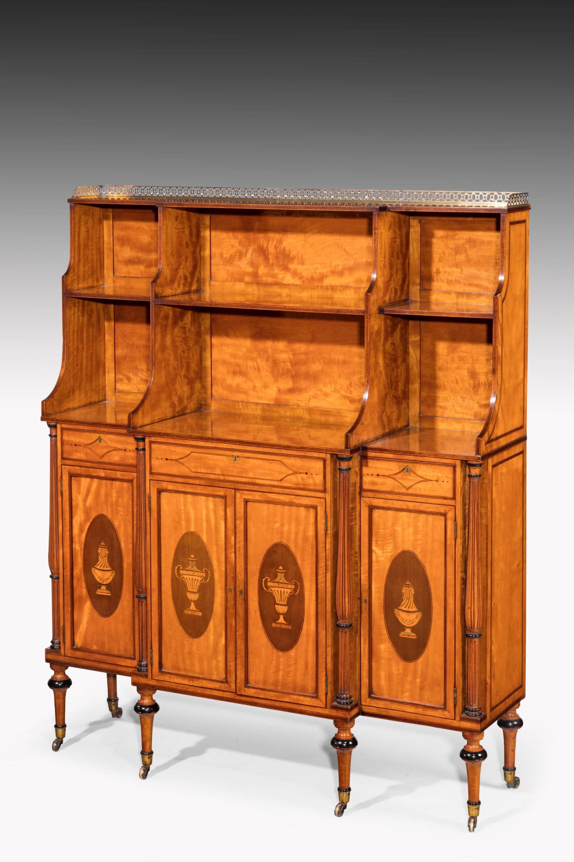 A quite exceptional pair of satinwood marquetry and parquetry breakfront dwarf cabinets. The upper sections with bookshelves surmounted by a pierced brass gallery. Oval patterns on the doors with neoclassic urns. Supported on fine turned feet with