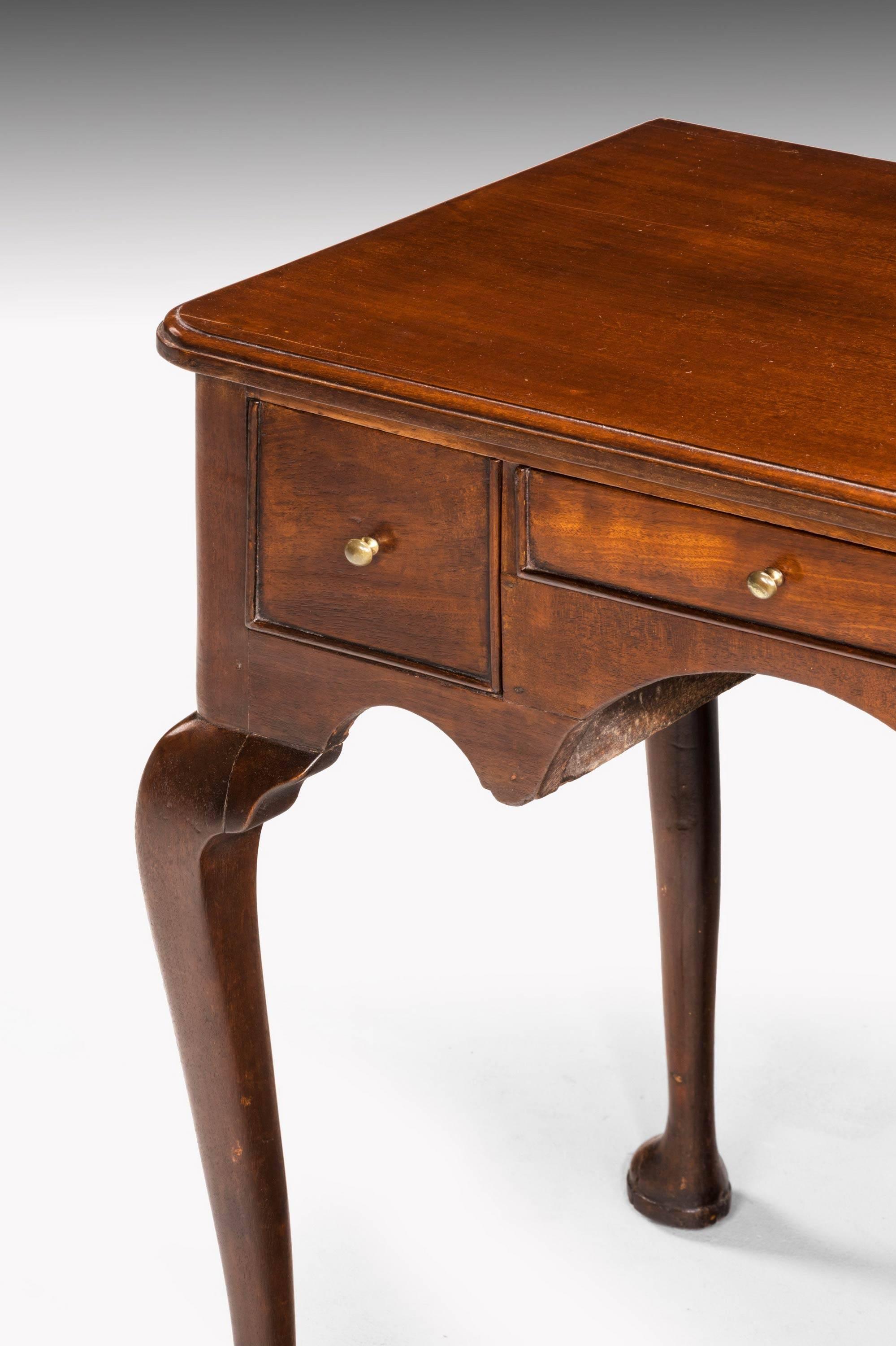 A good quality mid-18th century mahogany lowboy on well shaped cabriole supports. The top with rounded corners. Incorporating three drawers. 

N.