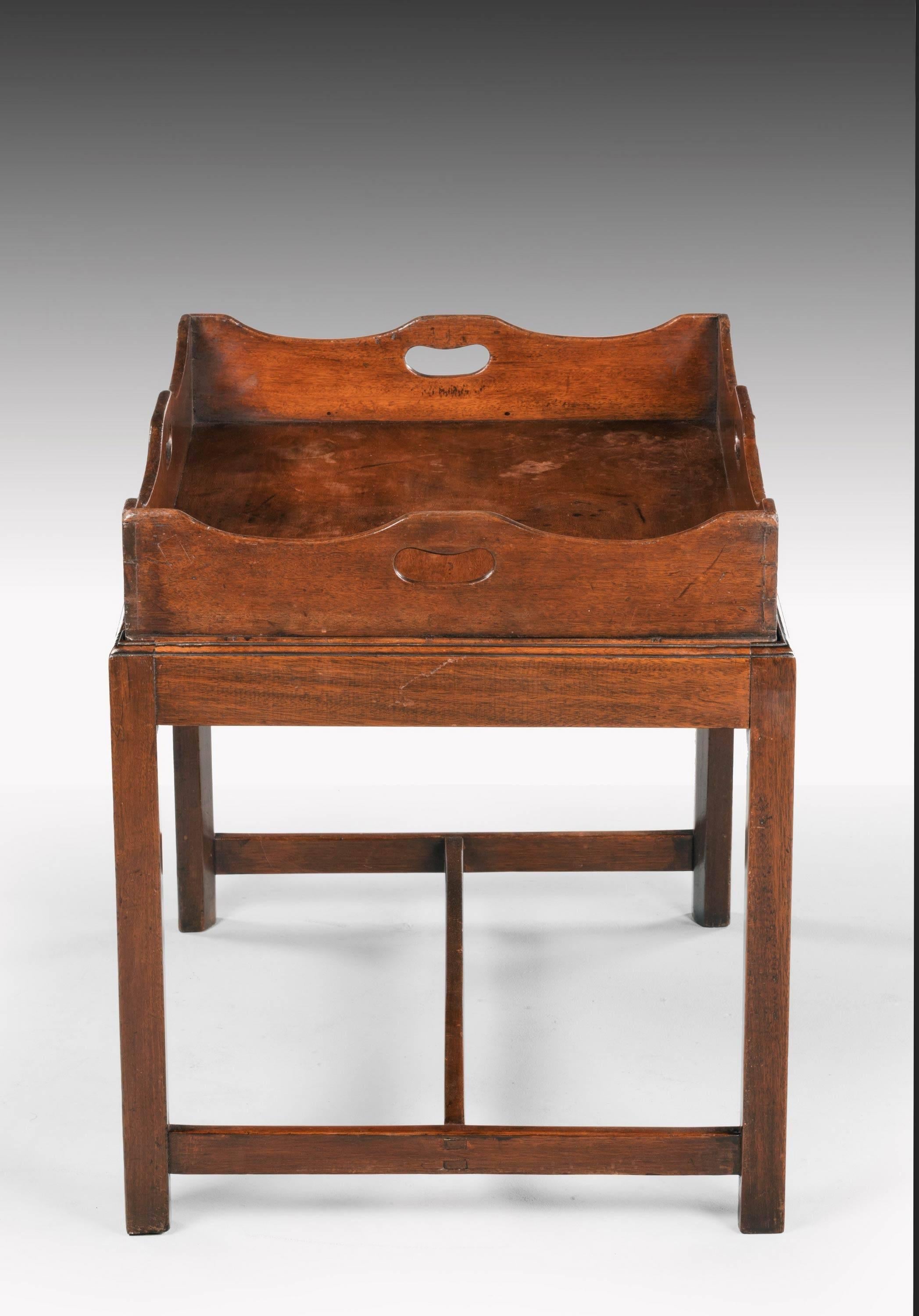 A large George III period mahogany tray with a shaped and swept border. The tray with handles to each side of the gallery. Now on a contemporary stand.

 