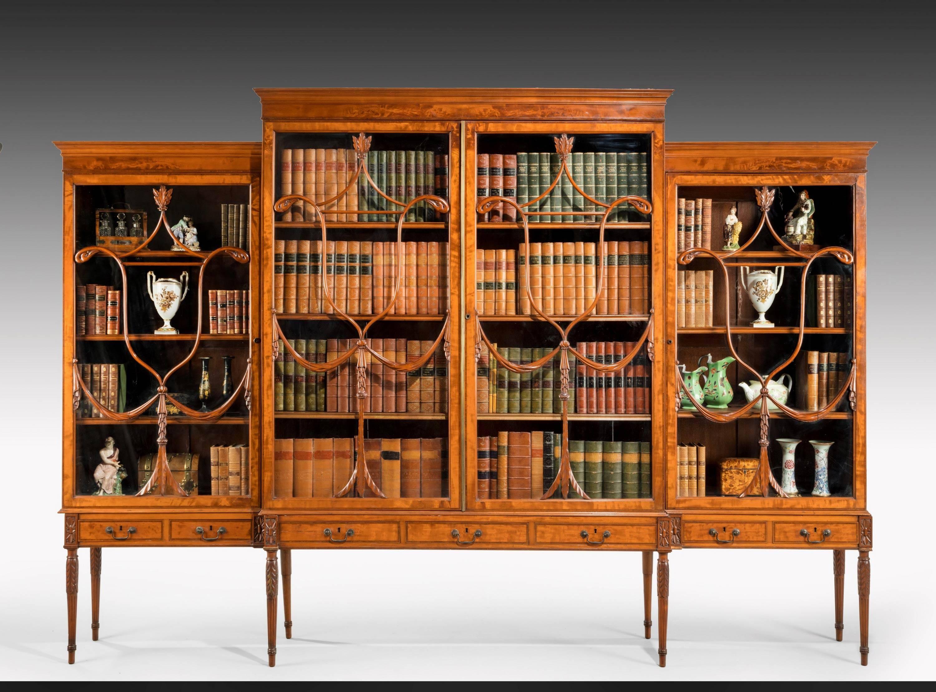 An unusual George III period mahogany breakfront bookcase. The top beautifully drawn with elaborate and finely carved astragals. Retaining the original Georgian glass. The base rebuilt in a rather more delicate way than would have been in the