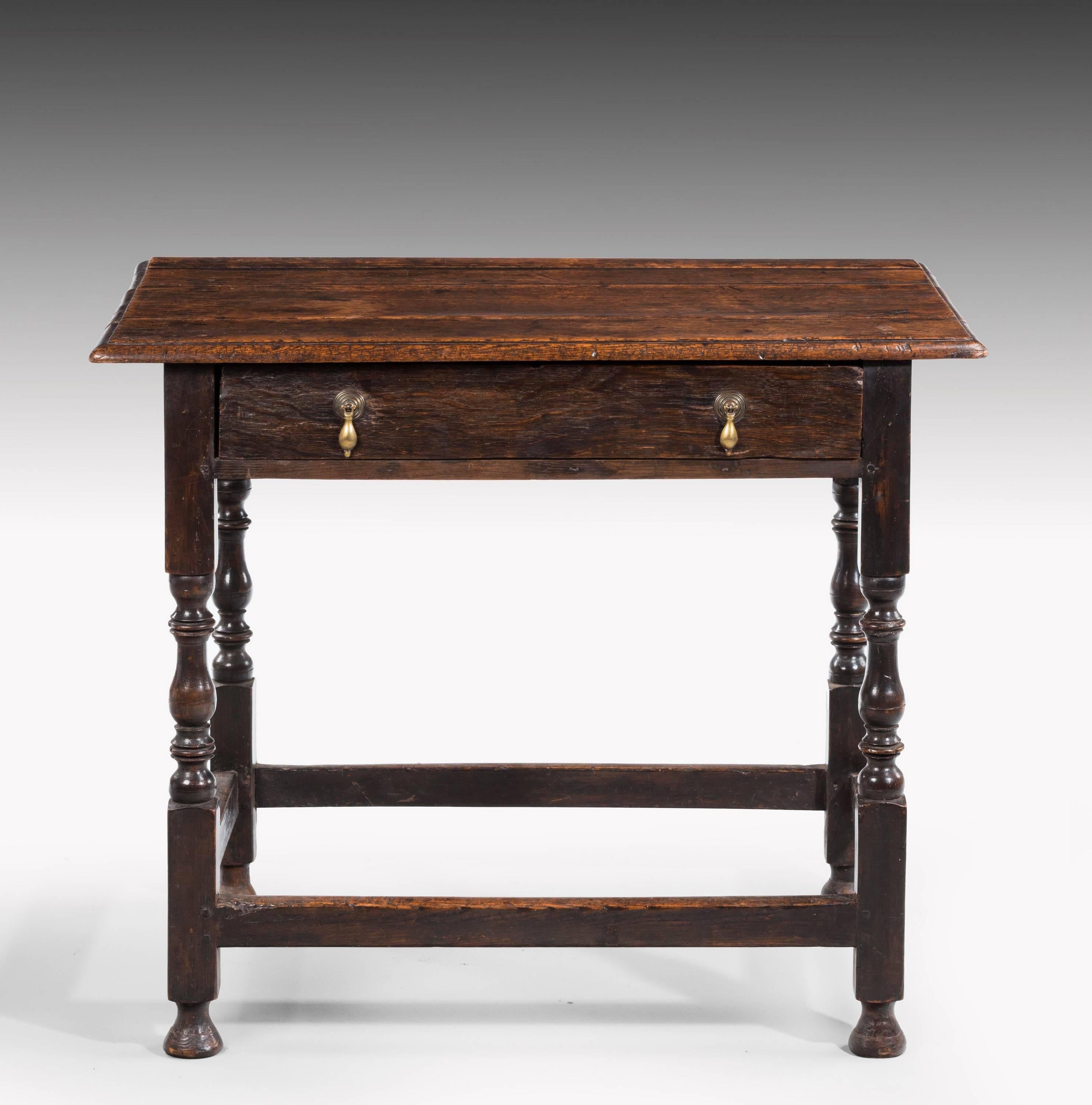 An early 18th century side table incorporating a single drawer of fine original patina and color. On finely turned baluster supports over square section cross stretchers.

 