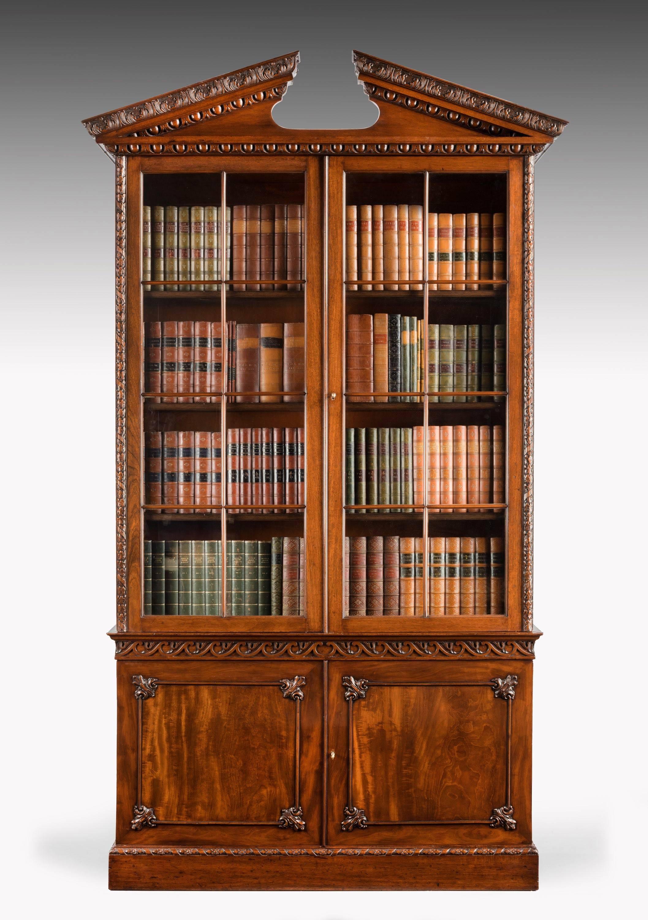 A good and architecturally strong Chippendale period mahogany low waisted bookcase. The upper section retaining the original glazed doors. The lower doors of matching left and right hand veneers with sharply carved detail. The top with Egg and Dart