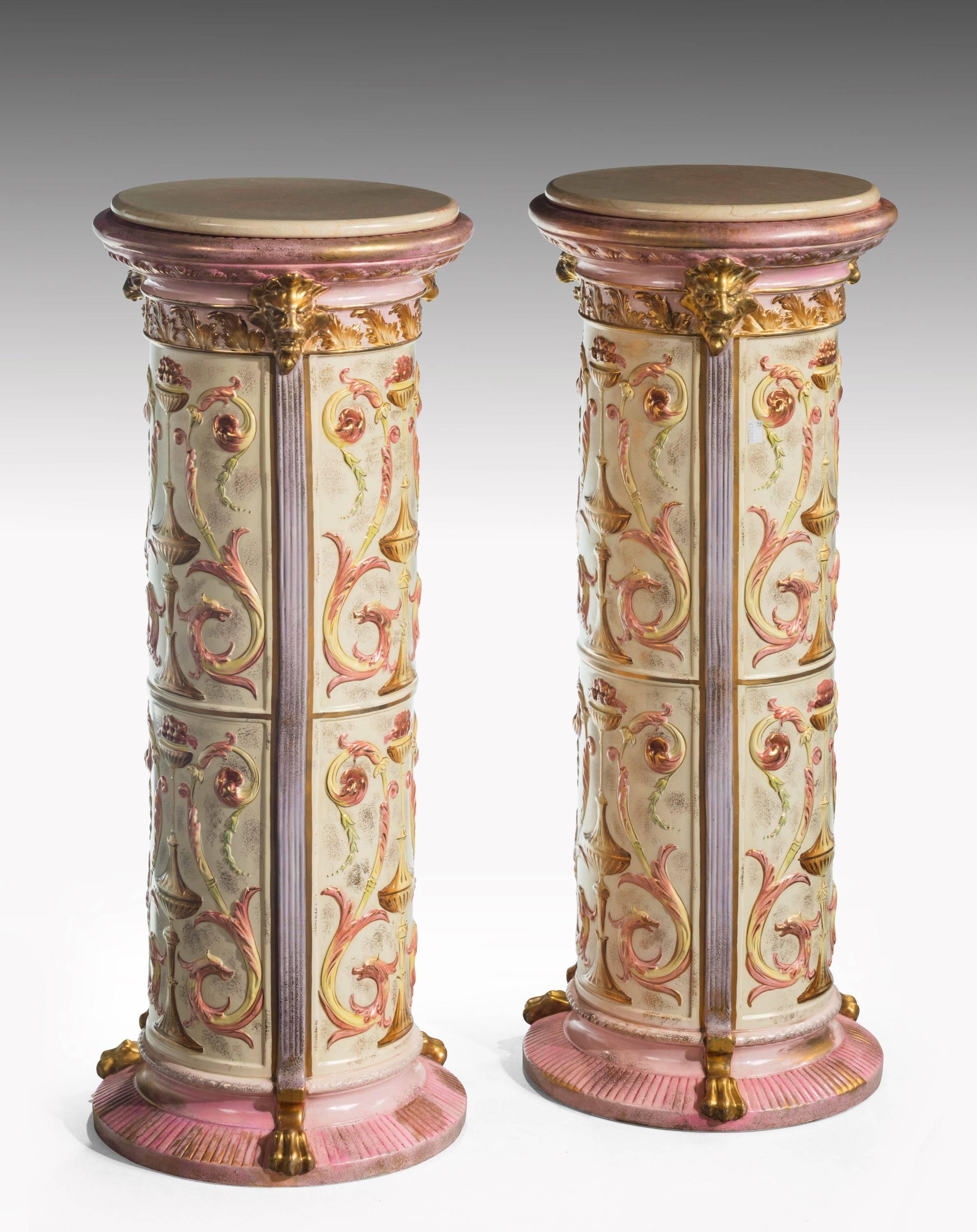 A finely designed pair of pottery columns with elaborate scroll and neoclassic decoration. Replaced marble tops. 

N.