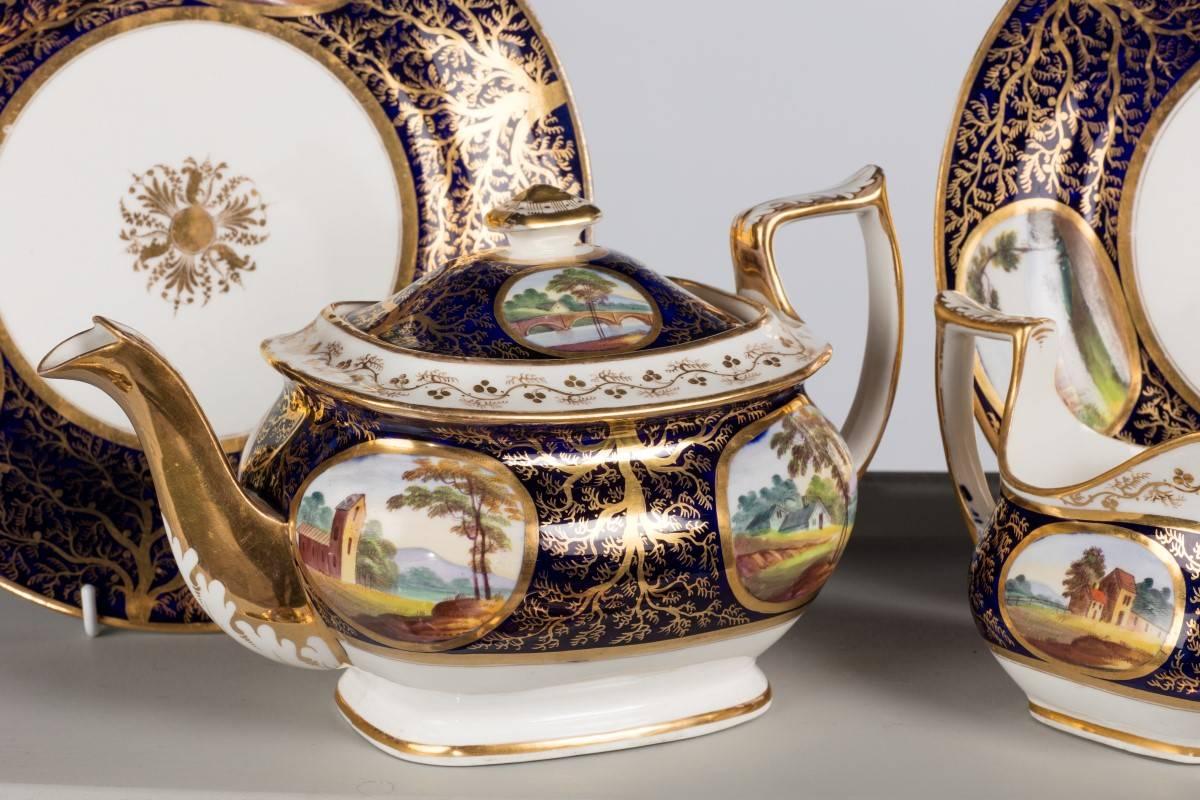 Early 19th century part tea service. The reserve panels with country scenes including bridges, rivers etc. The gilding of seaweed form. With restorations.

One tea pot
One sugar
Two plates
Four cups
Four saucers
One oval dish
One jug.
 