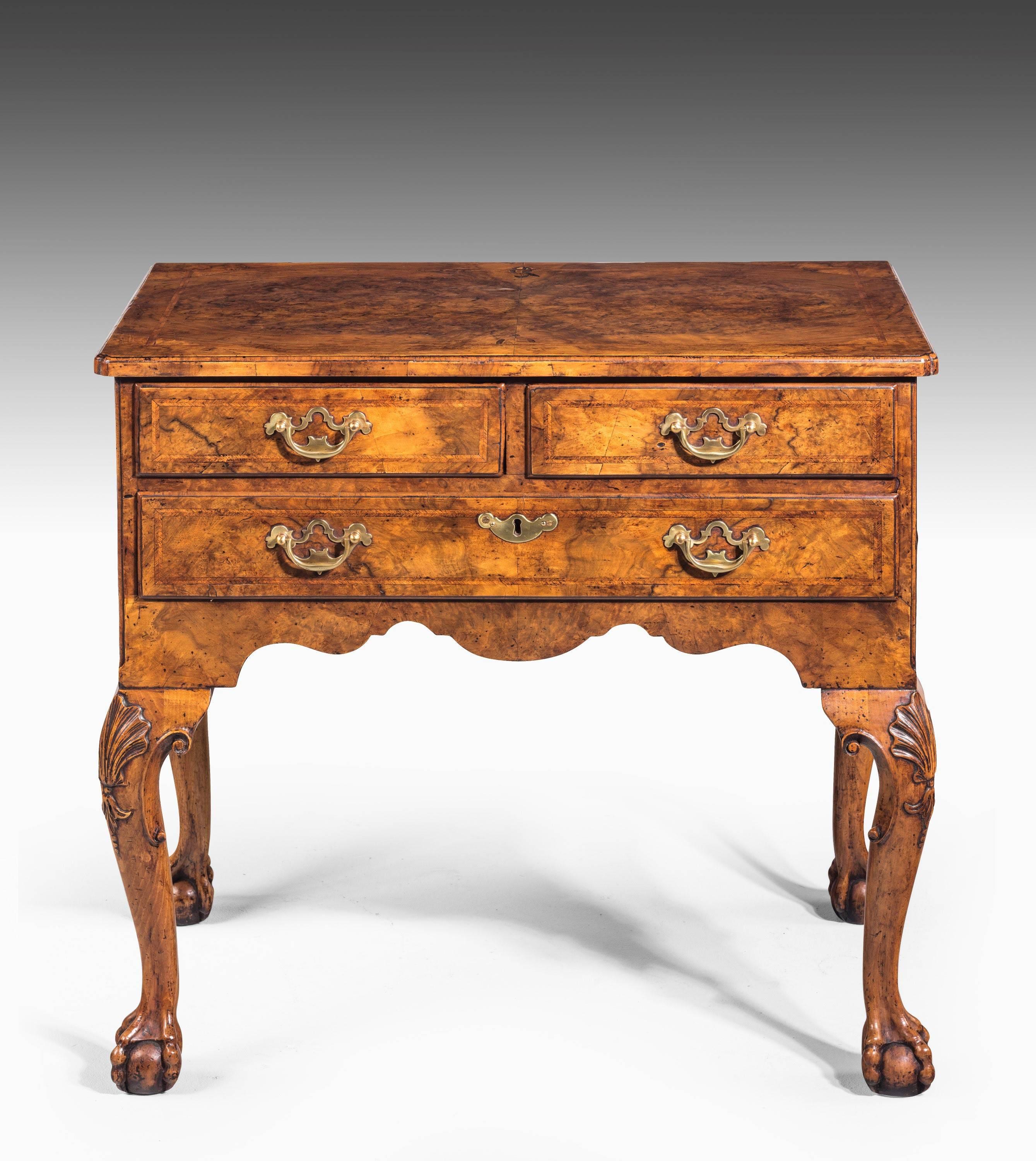 A near pair of George I period beautifully figured walnut lowboys. Well carved cabriole supports terminating in claw and ball feet. The knees with elaborate fans. Herringbone inlay on all sides.