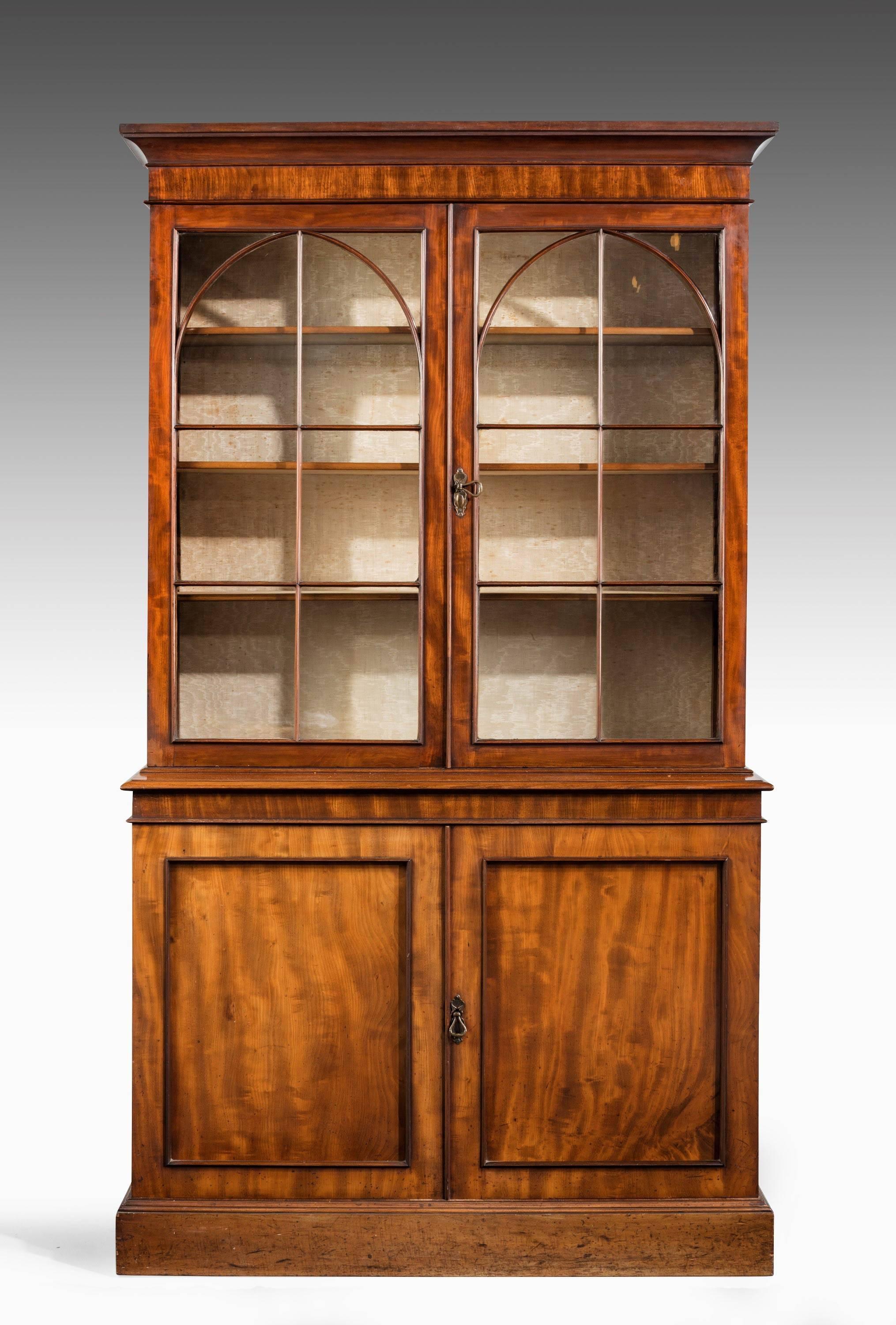 A Regency period mahogany bookcase. The glazed top section with slight Gothic tracery. The base well figured with left and right hand matching panels.
