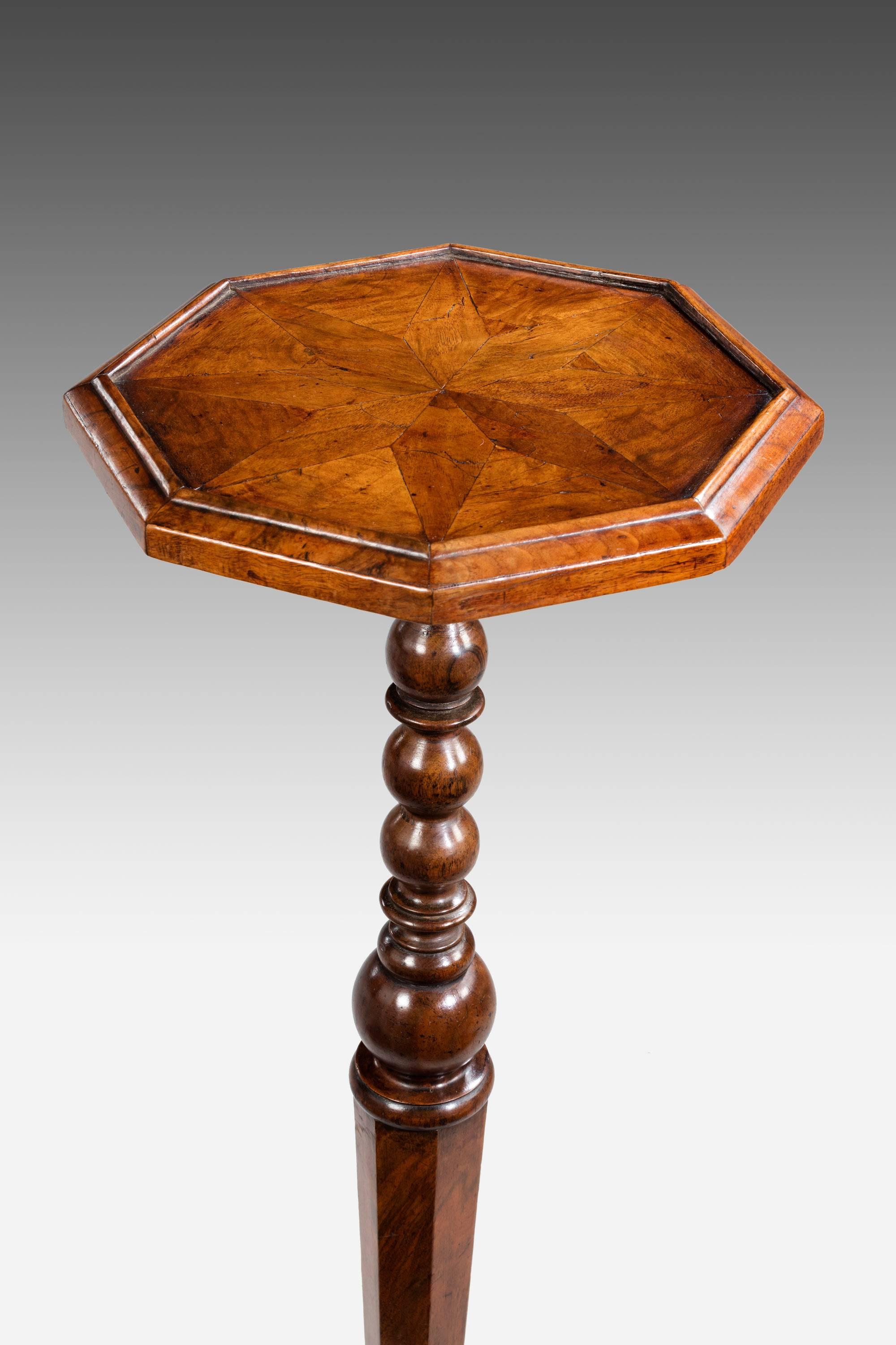 A 17th century William and Mary period walnut candle stand or torchere stand. The hexagonal centre stem with finely figured walnut veneers, over three elaborate feet. The top of very good color and patina, carefully sectioned in diamonds and