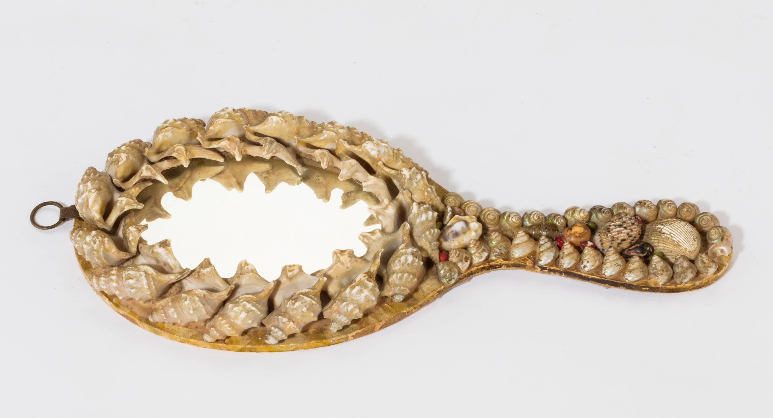A most unusual shaped sailorwork shell encrusted hand mirror.