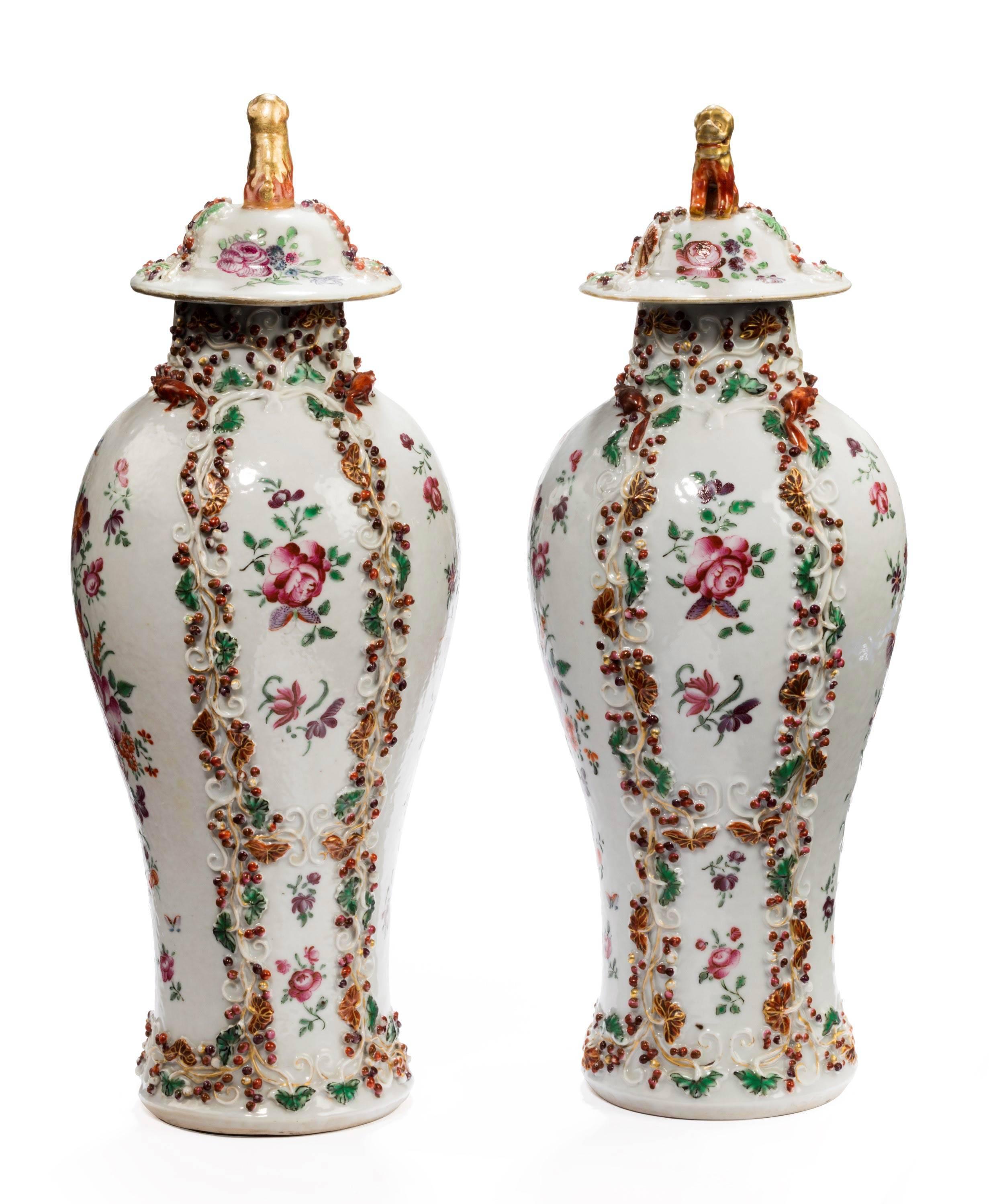 A pair of oriental porcelain baluster shaped vases with raised decoration. The top collar with dogs of Foo. Excellent overall condition.
