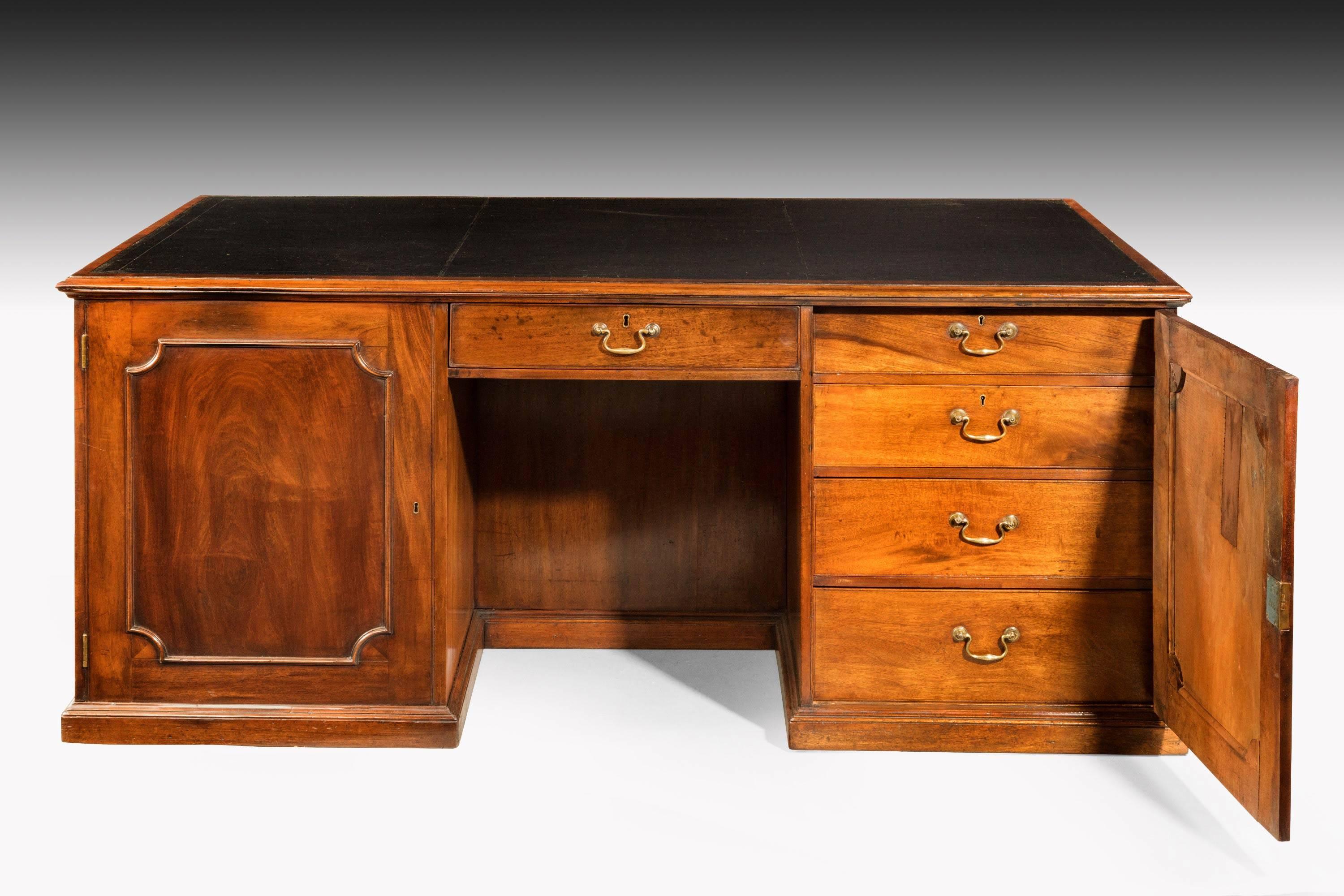 A very good Chippendale period mahogany desk of unusual form. The ends with blind drawers. The fitted sections behind the pillars which are original. Good swan neck handles.