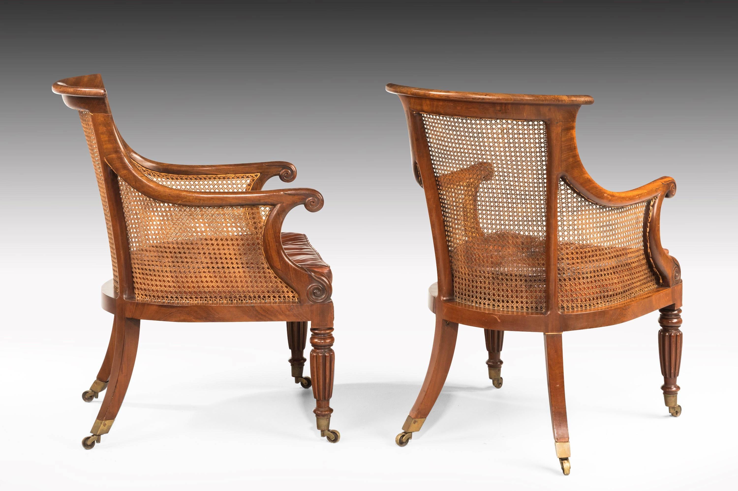 A fine pair of Regency period bergère library chairs. Swept arms over very well carved turned and reeded supports. Original shoes and castors of particularly generous size. Exceptional unrestored condition including the polish.

Measure: Seat