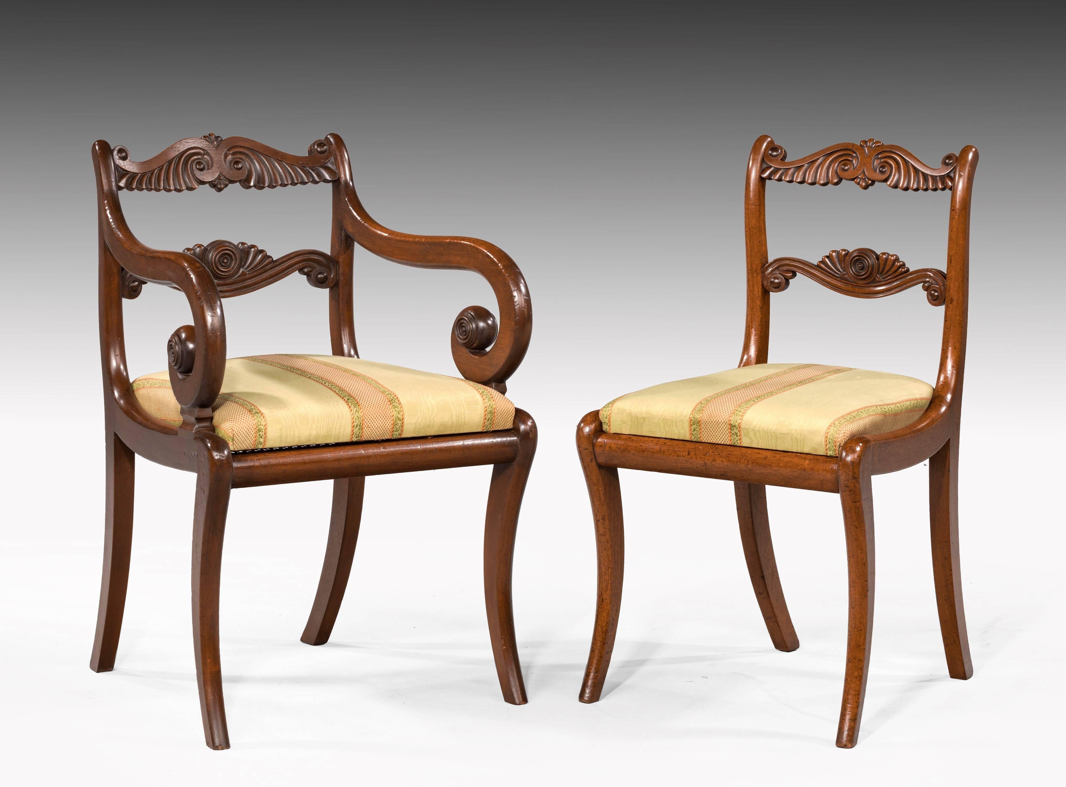 An elegant set of 12 (ten plus two) Regency period mahogany dining chairs in quite extraordinary good original condition, including the cane seats and polish. Sabre legs. The top and centre horizontal splats beautifully carved with fronds.

The