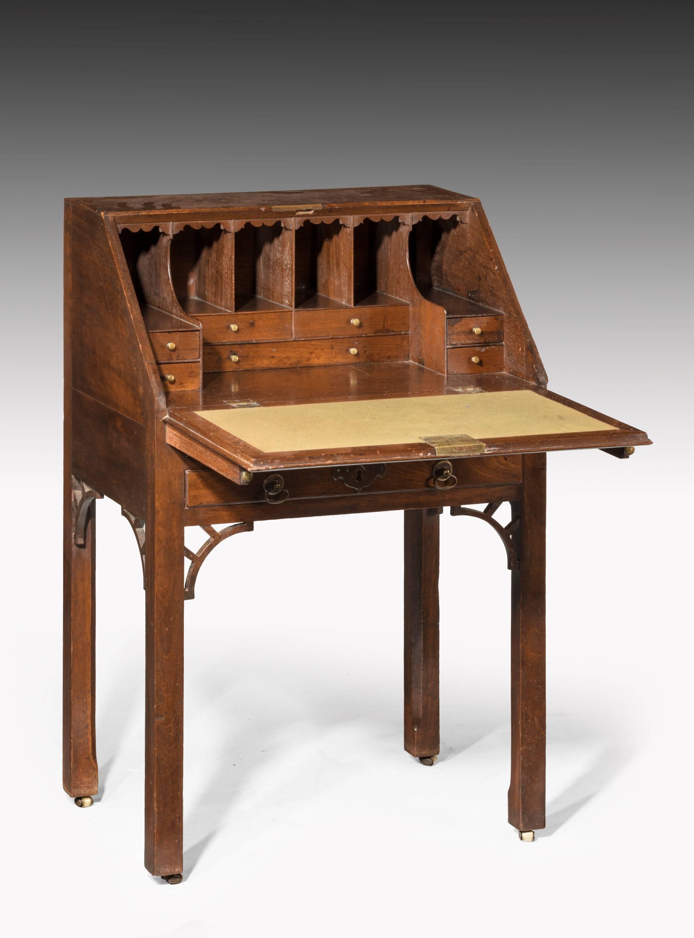 George III period mahogany bureau on stand with open fretwork to the tops of the legs with well fitted stepped interior section. Retaining original barrel castors and original brassware, untouched condition.