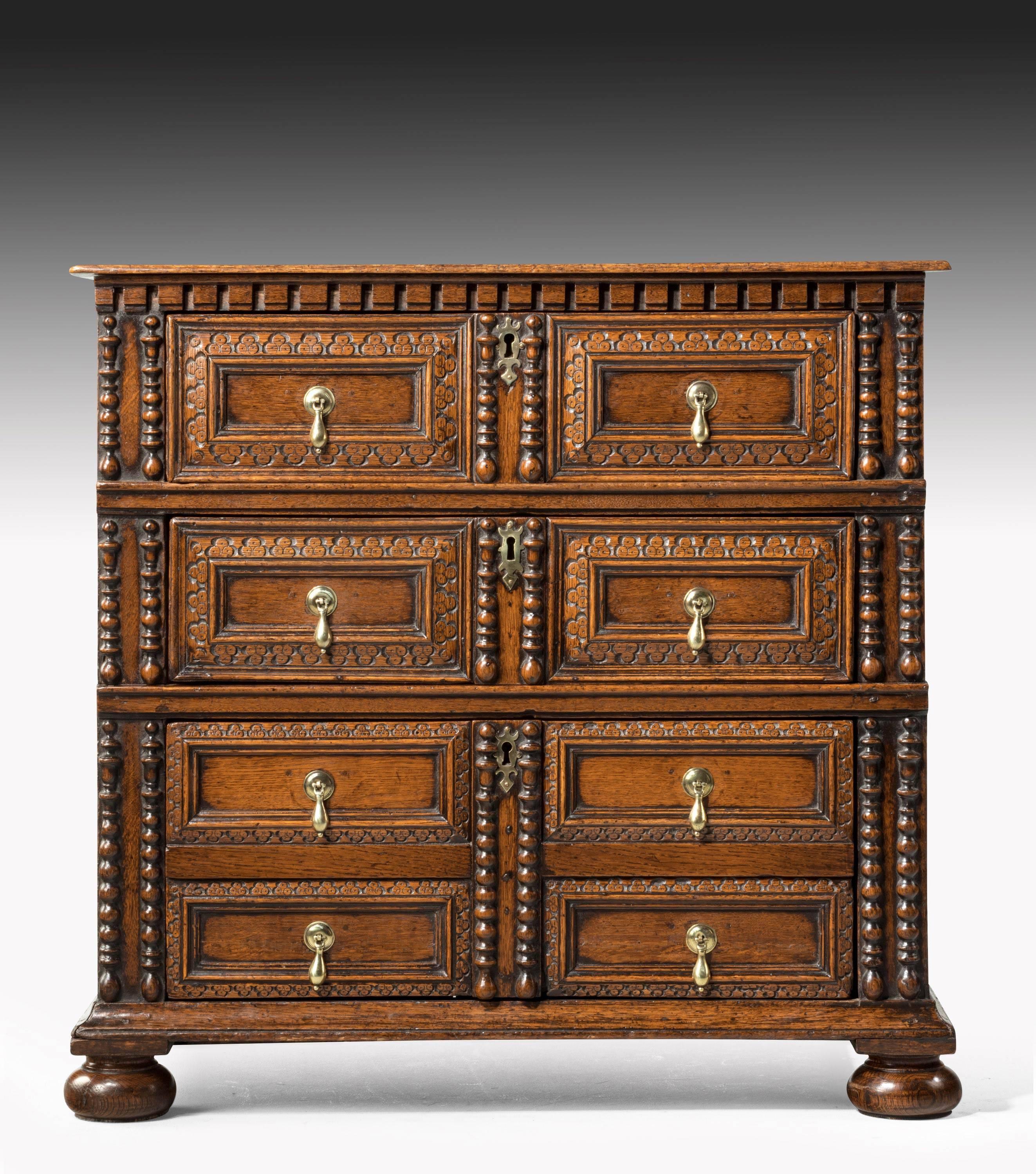 A fine and original oak chest of drawers. 1690. Unusual drawer formation with scratch and deep carving. Applied mouldings to the front and retaining the original bun feet. Most unusual design and exceptional patina.

  