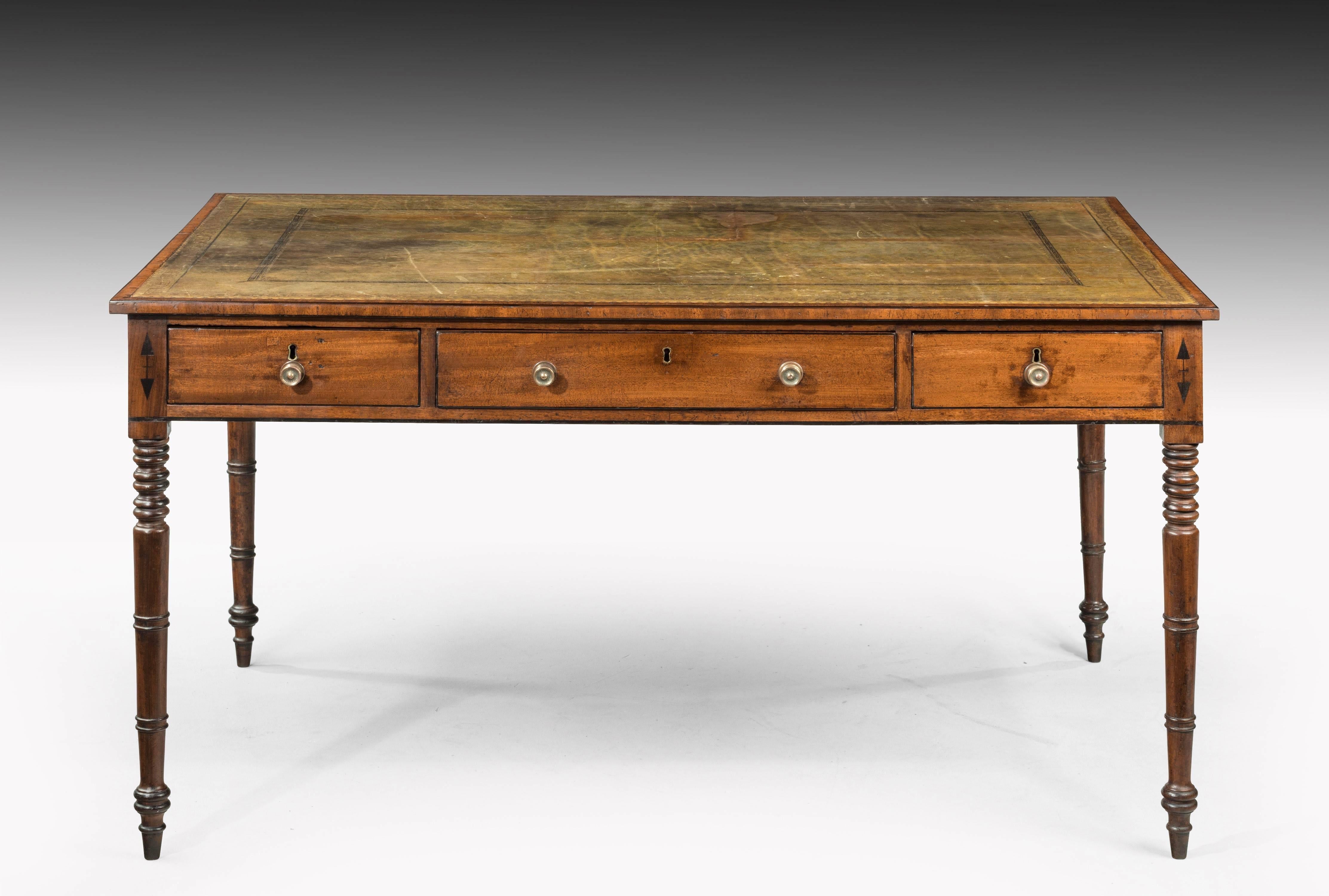 A late Georgian mahogany library table with three drawers to each side. Standing on finely turned tapering supports.