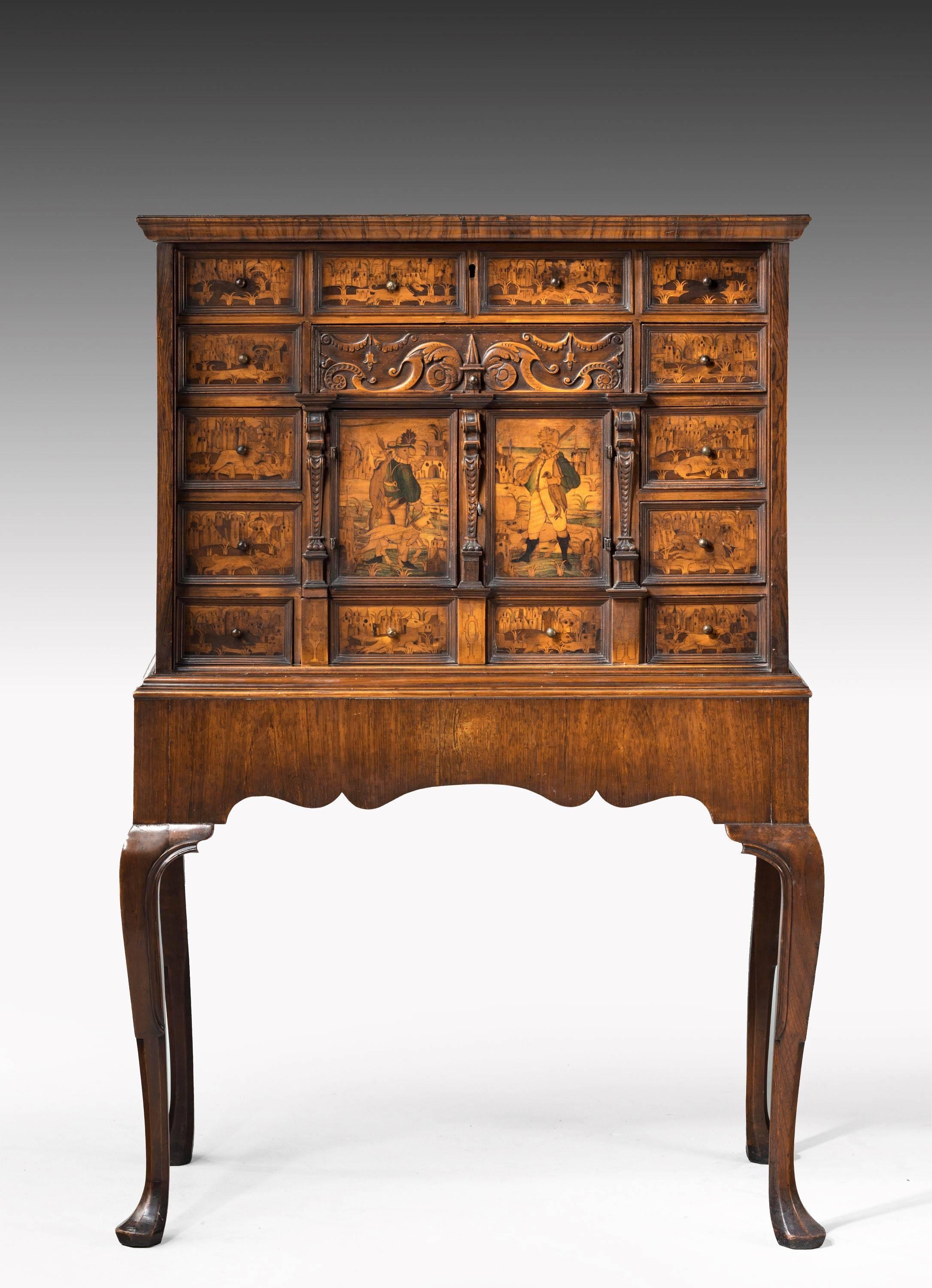 A most unusual continental walnut cabinet on stand of very elaborate marquetry design. The top beautifully faded in walnut. The façade with exotic scenes and carved detail.