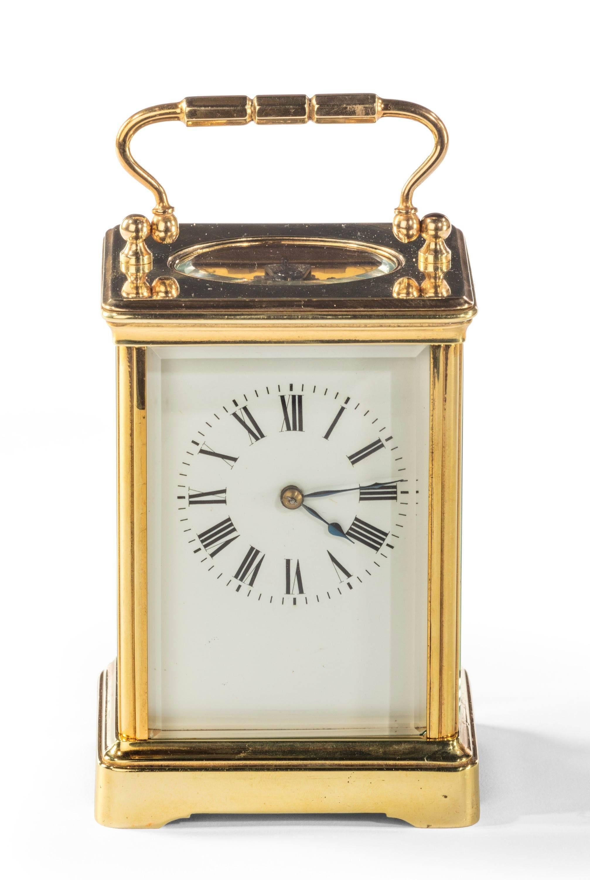 A brass carriage timepiece, unsigned, 20th century, the eight-day movement with silvered platform lever escapement with white enamel Roman numeral dial and spade hands, in a lacquered brass corniche case with bevel glazed panels, 5 ins high