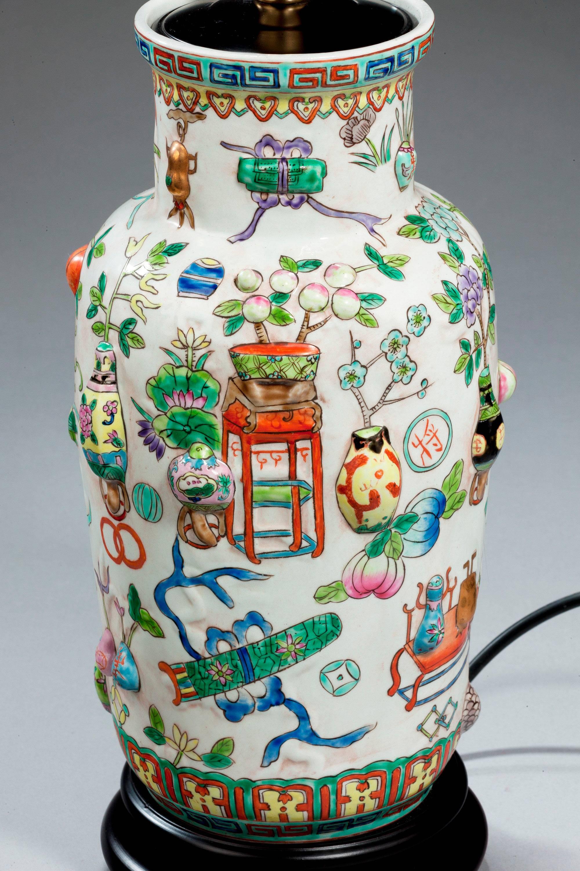 A single porcelain lamp of Canton design, with raised 'one hundred antiques' enamels. Modern.

Canton porcelains are Chinese ceramic wares made for export in the 18th to the 20th centuries. The wares were made, glazed and fired at Jingdezhen but