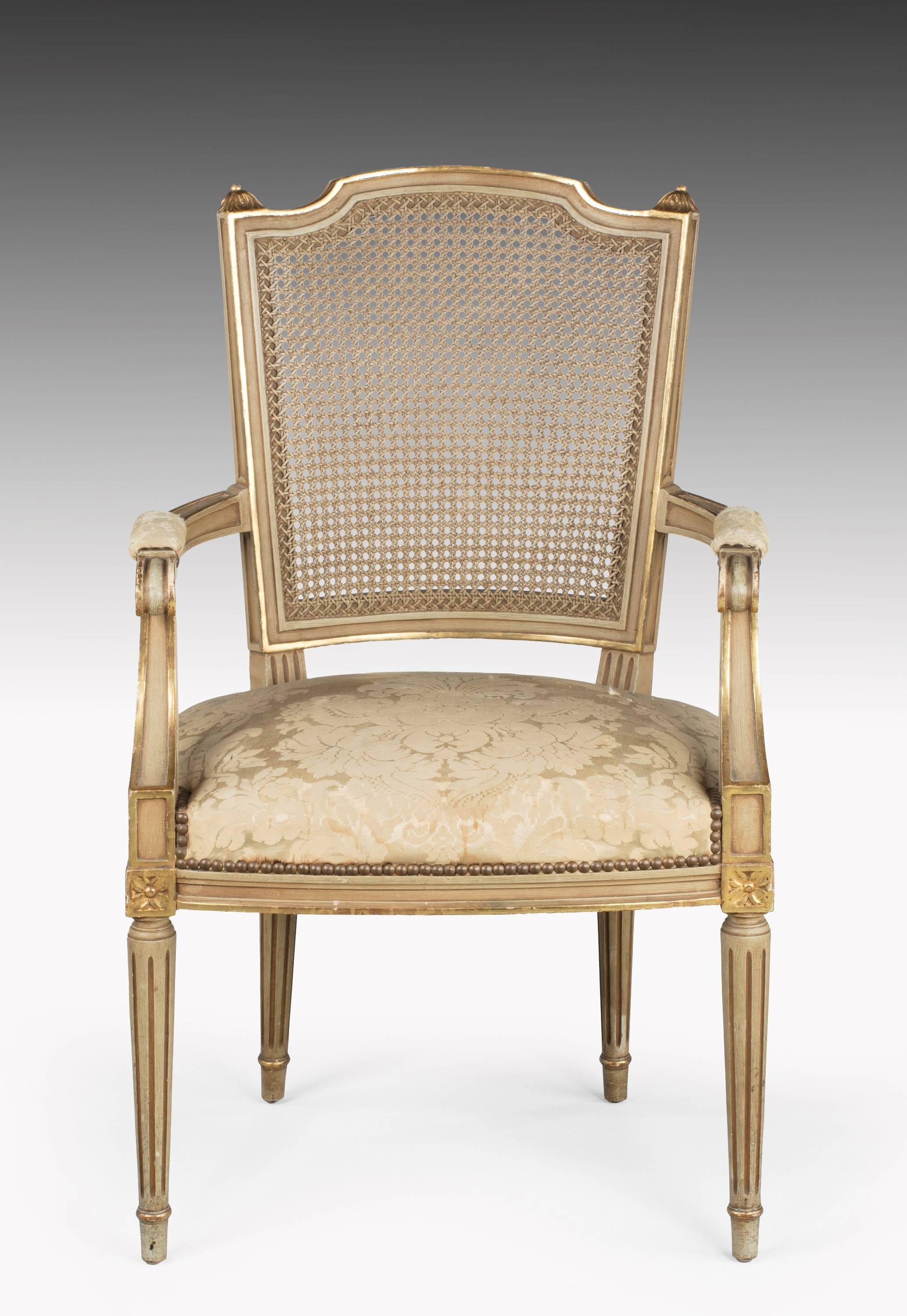 A good pair of early 20th century French painted and parcel gilt elbow chairs. The ivory ground somewhat tired now but still in very good condition and the gilding original. 

Measures: Seat height 18 inches.