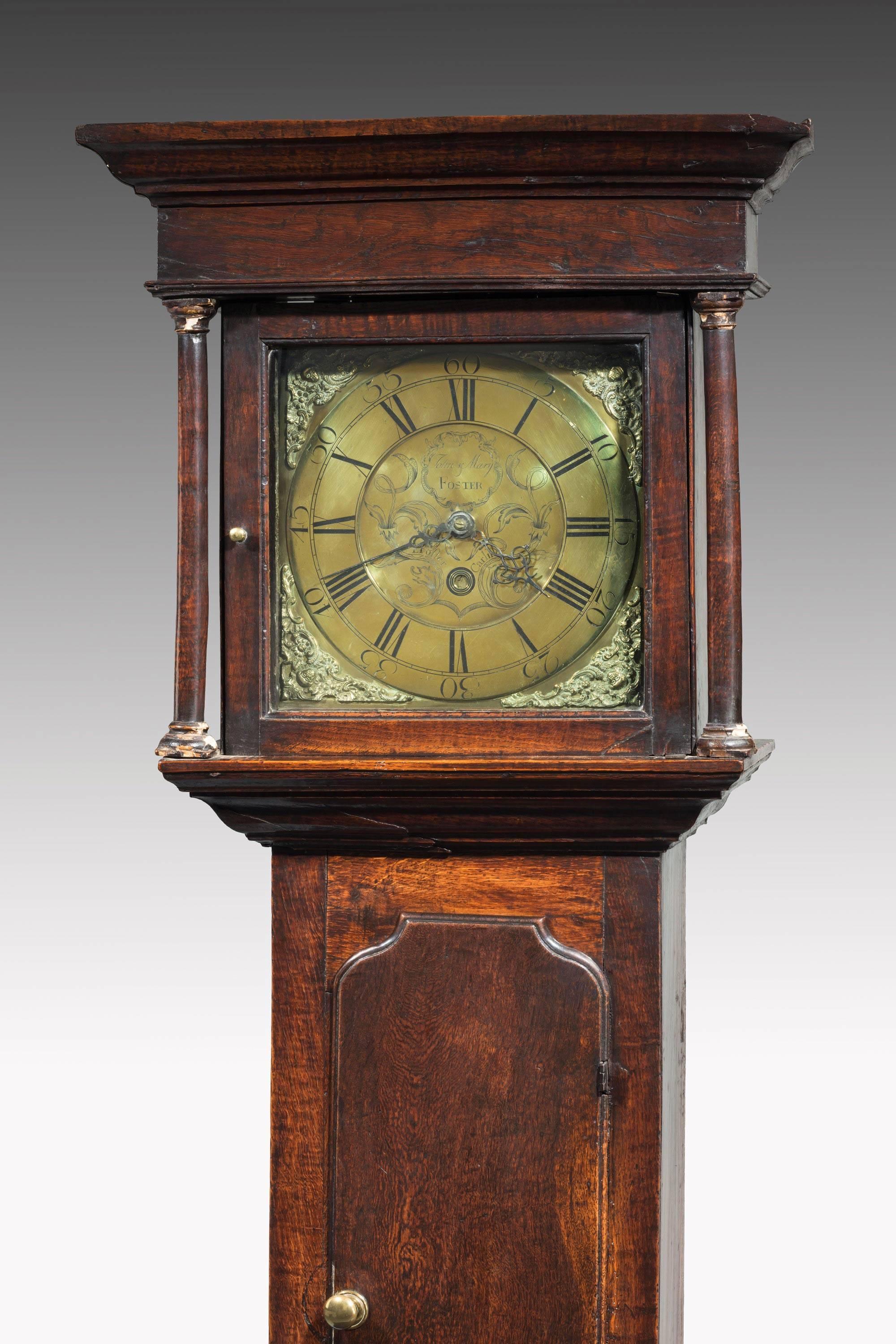 George III period oak longcase clock by E. Foster of Carlisle, with thirty-hour movement, long trunk door and 12-inch brass square dial with date aperture, also inscribed 