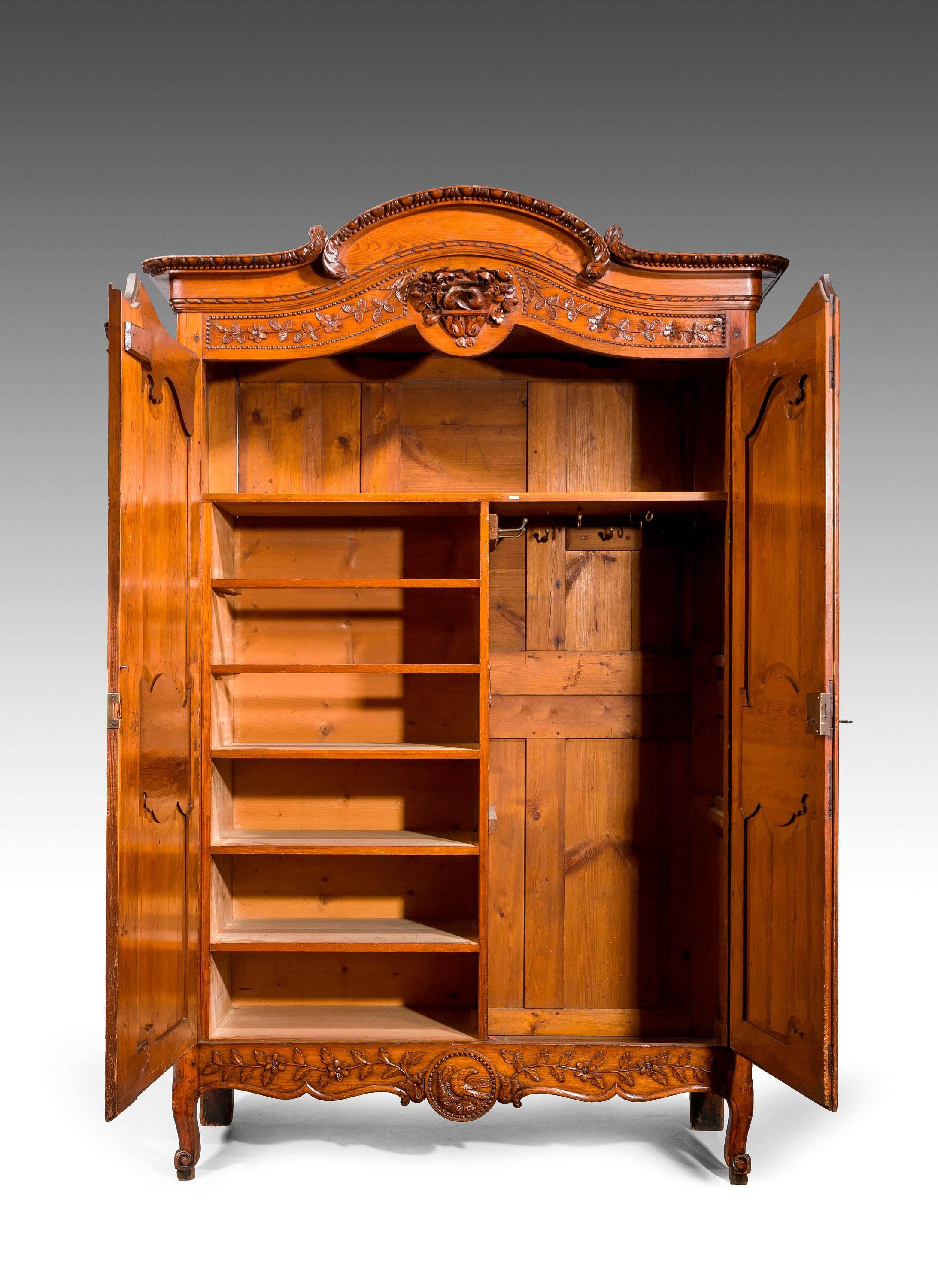 A very finely carved mid-18th century chestnut armoire, the cupboard of exceptional quality and in its fine original condition.