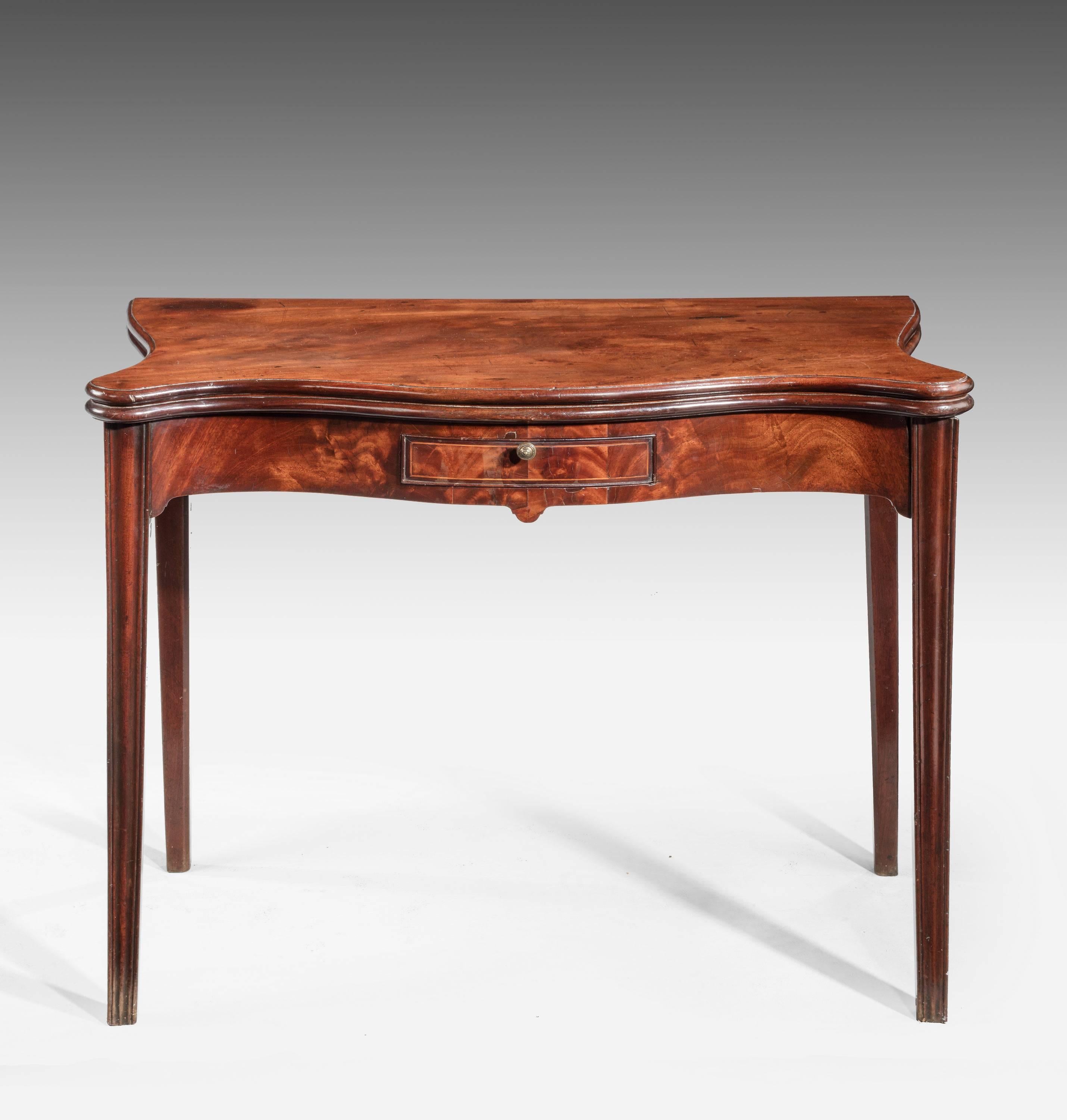 A fine Chippendale Period Serpentine Mahogany Tea Table. The very well figured top over square chamford supports. The Serpentine front with a drawer.