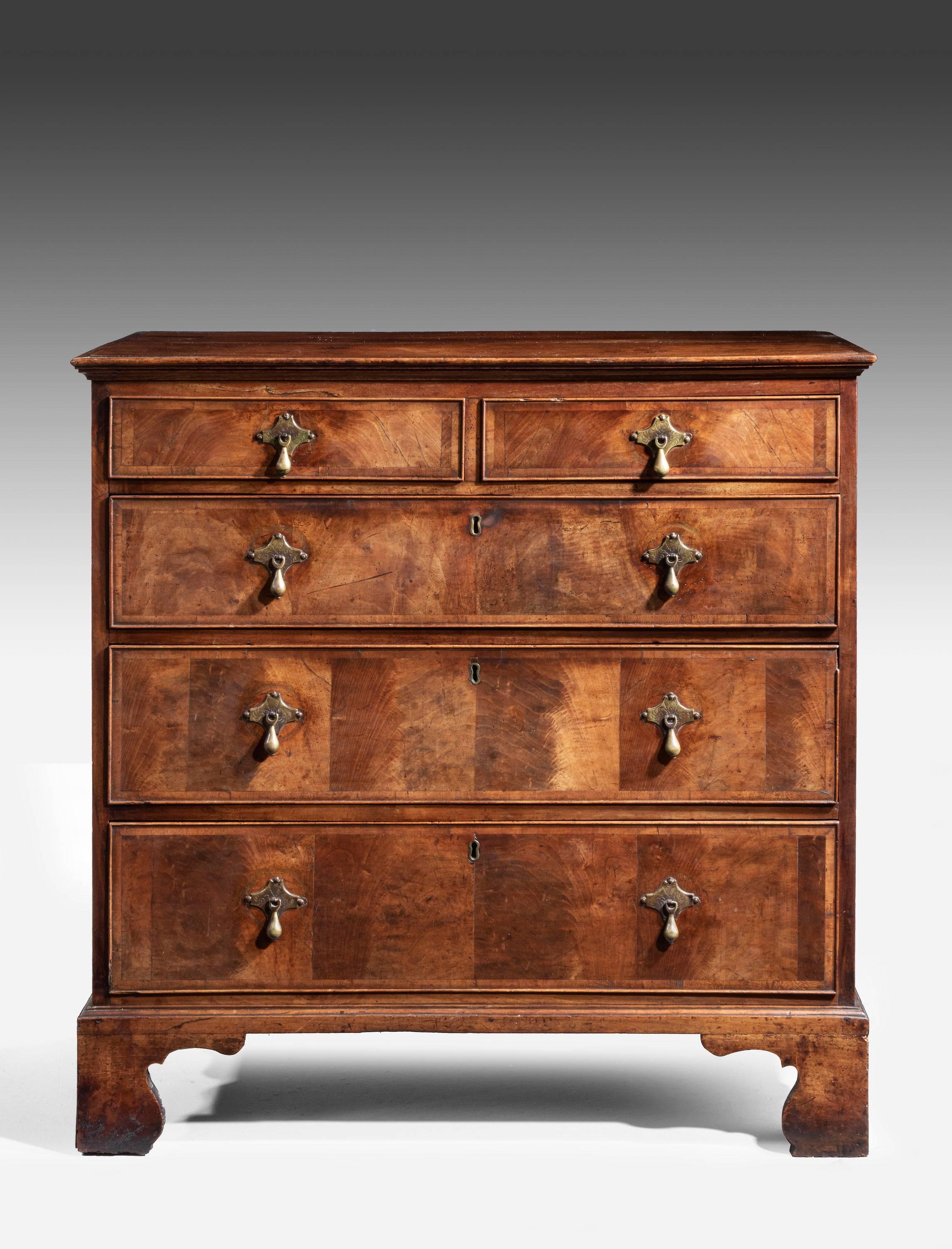 A attractive mid-18th century walnut chest of drawers. The ends of bone inlay and crossbanded. Period brass. High shaped bracket feet.