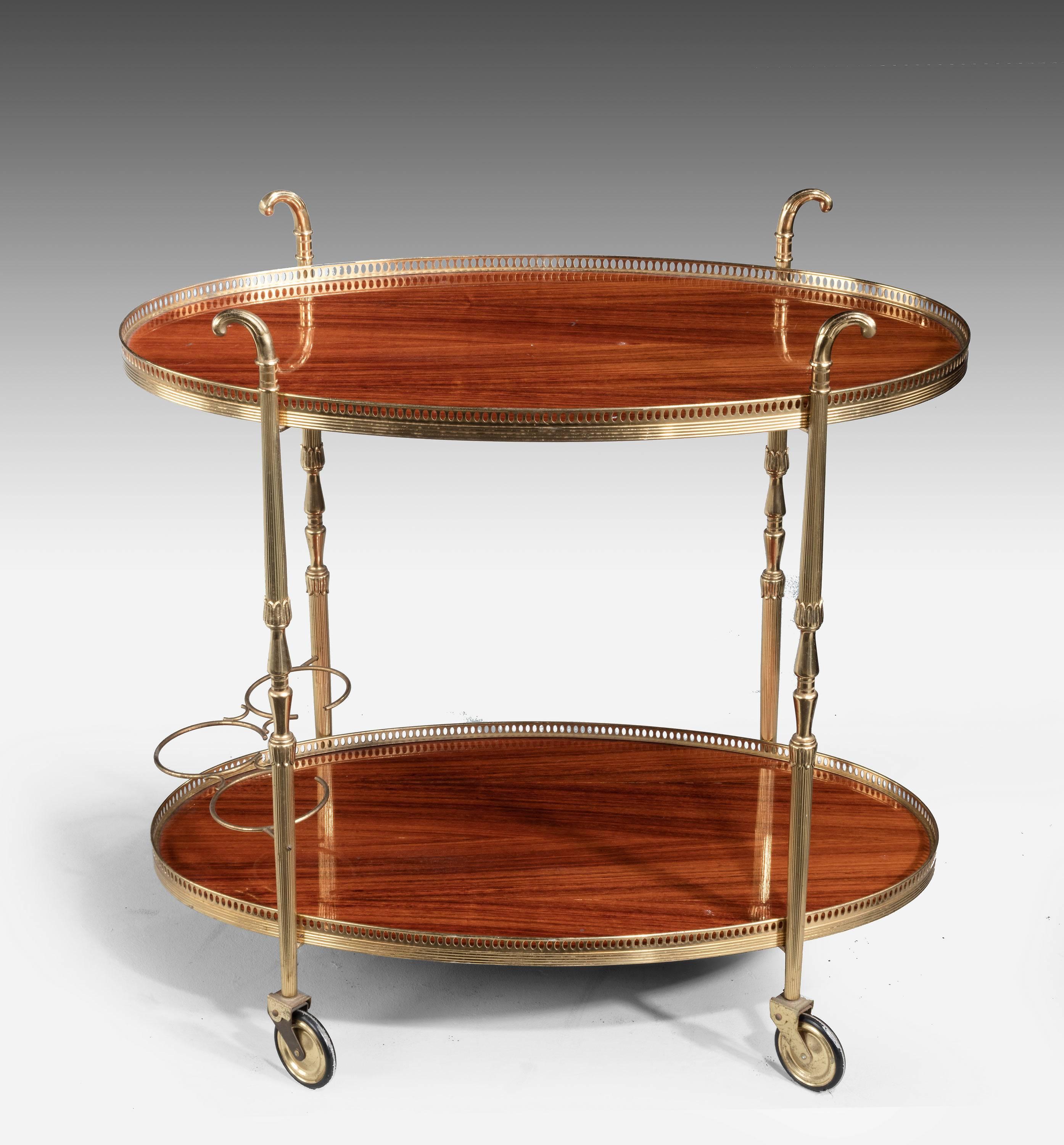 A Mid-20th Century Brass and Veneered Tea and Drinks Trolley. On large and original casters. The supports beautifully turned and with reeded decoration. Top and bottom with matching galleries.