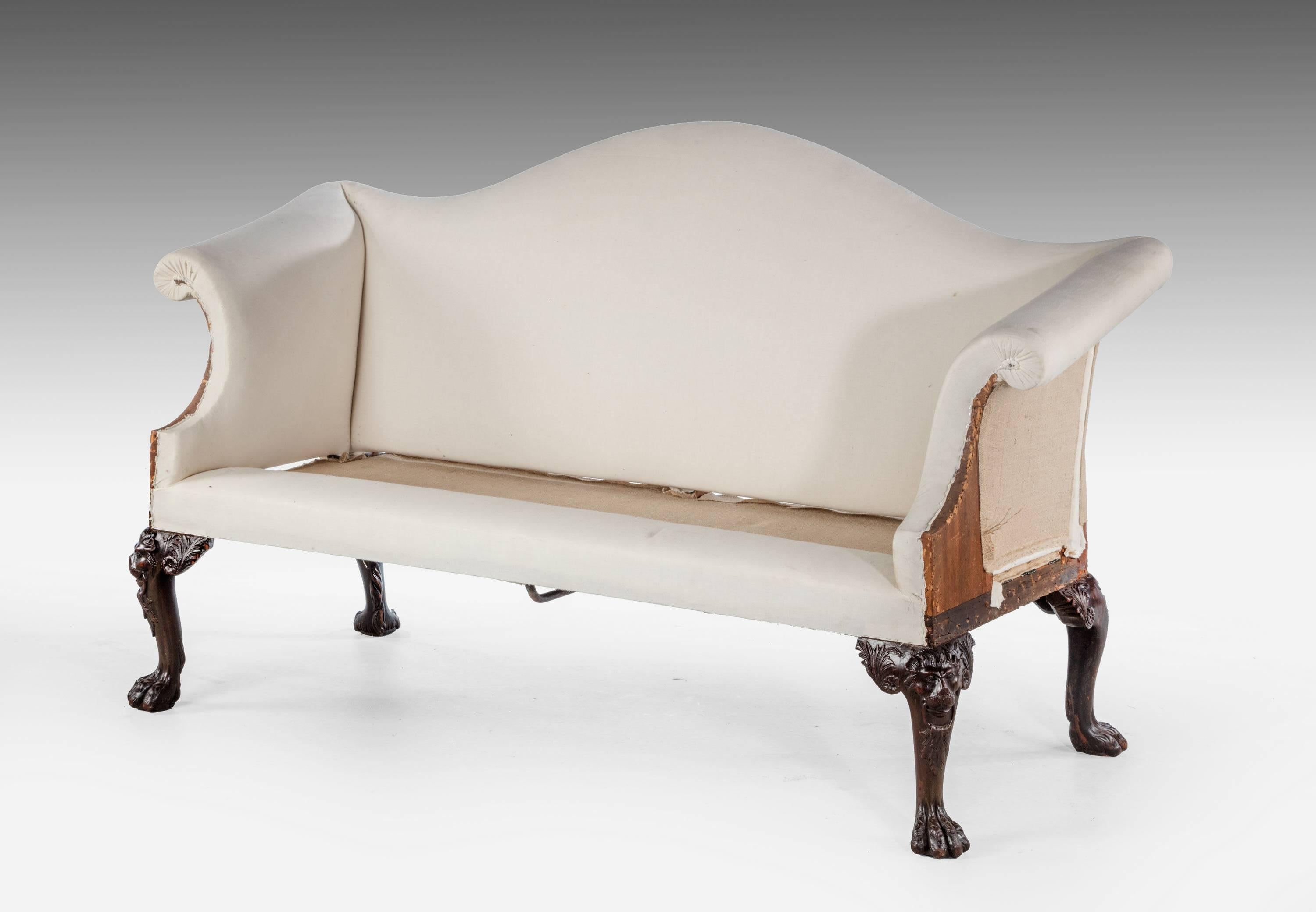 A very shapely mahogany framed two-seat sofa. With high Camel back and scroll arms. The supports with carved knees ending in paw feet. The feet carved with lion masks and foliage.

RR.