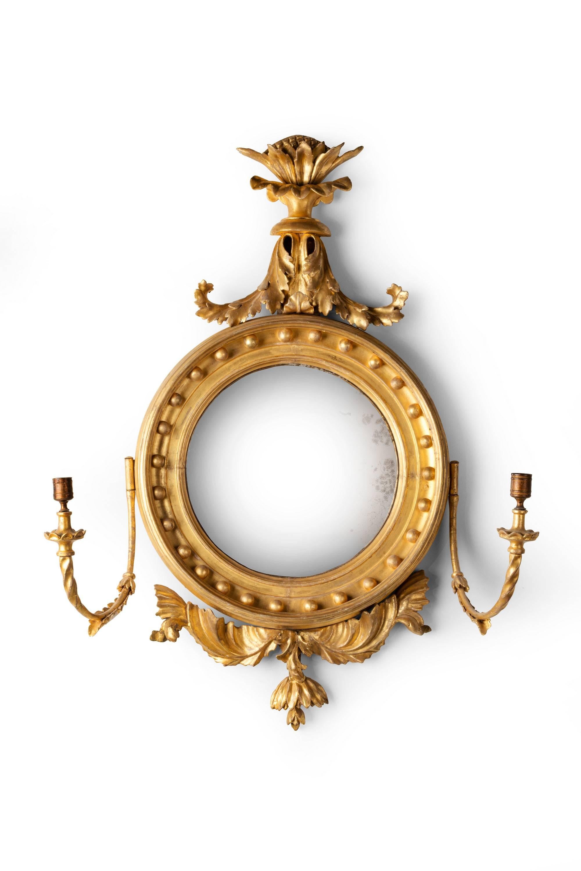 Regency period giltwood convex mirror with girandole candle arms.

