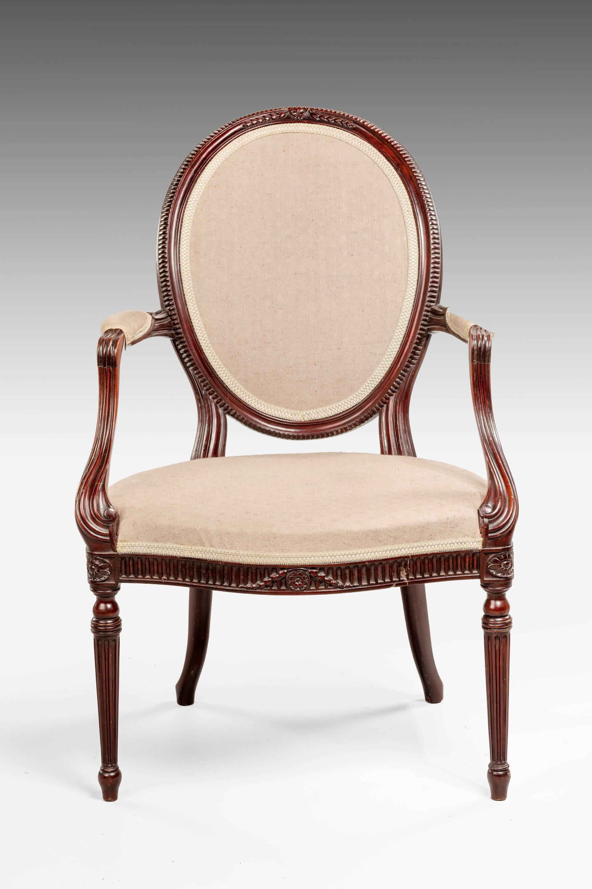 An elegant and well carved elbow chair showing Hepplewhite influence the oval back with continuous ribbed detail. The supports with swept sections, serpentine front with husk carving.

