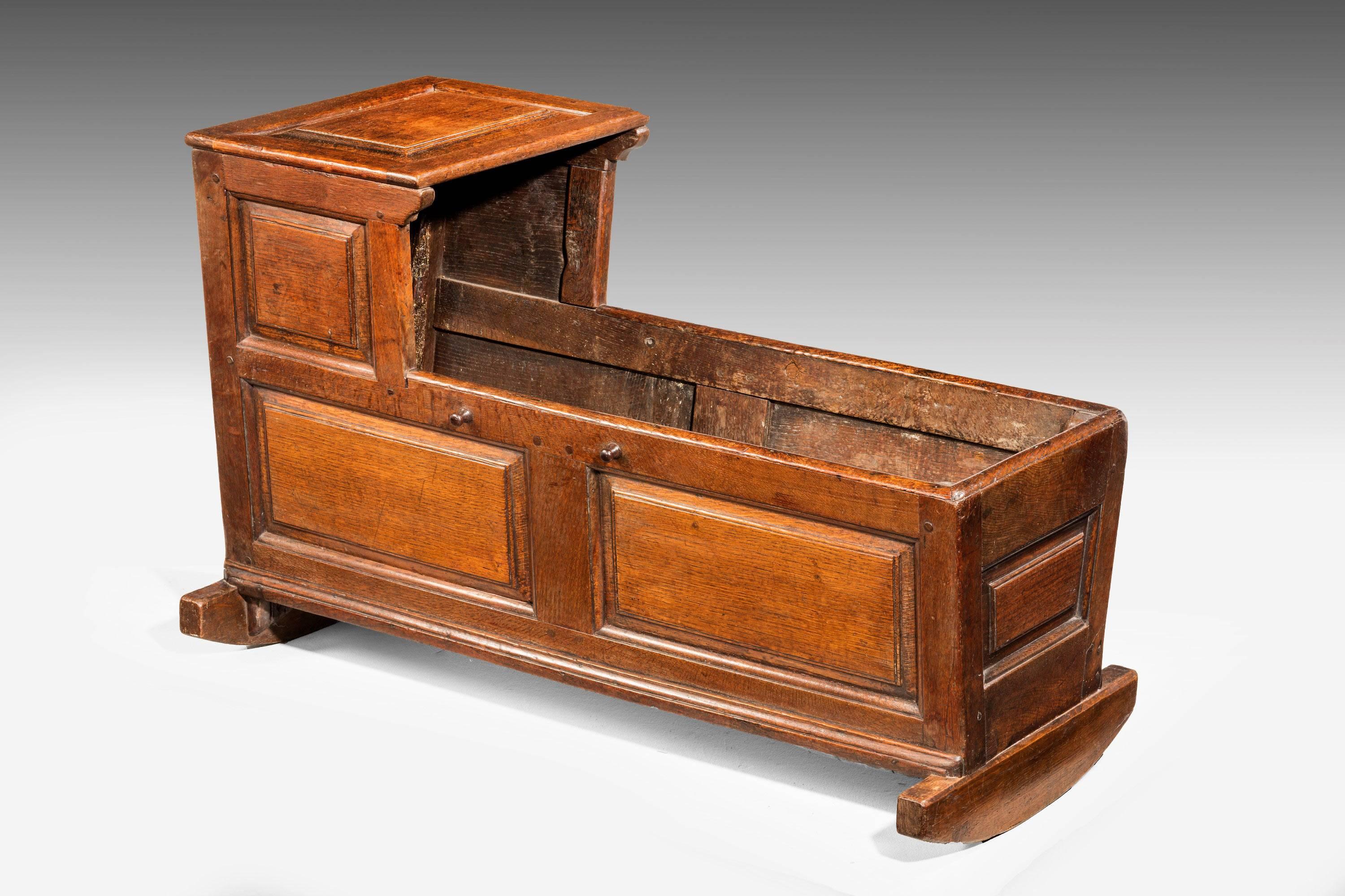 A good and original 18th century oak cradle. The timbers very well figured. The panelled sections to the top and sides. 

