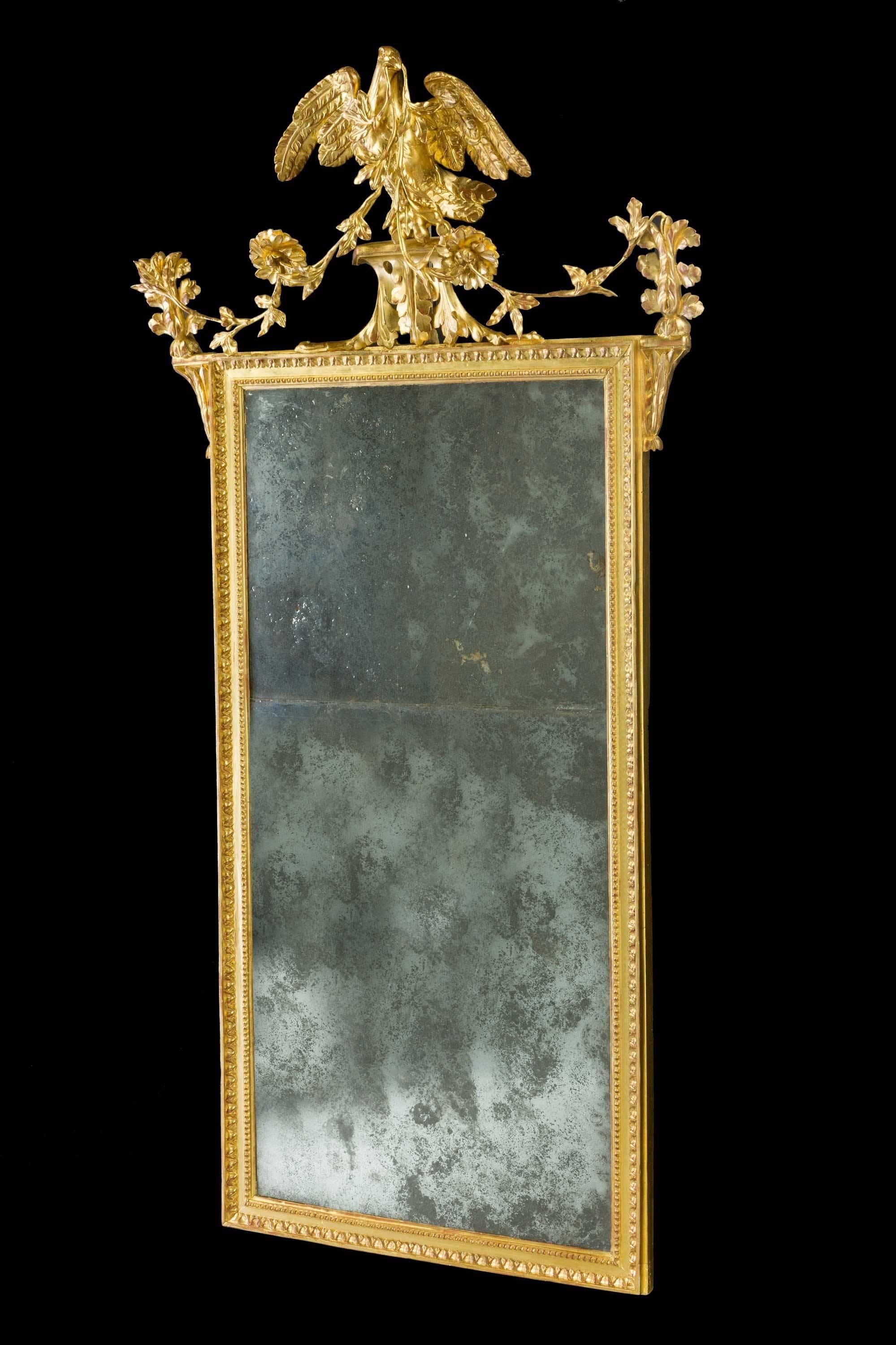 A late 18th century giltwood and carved mirror with an eagle or bird motif.