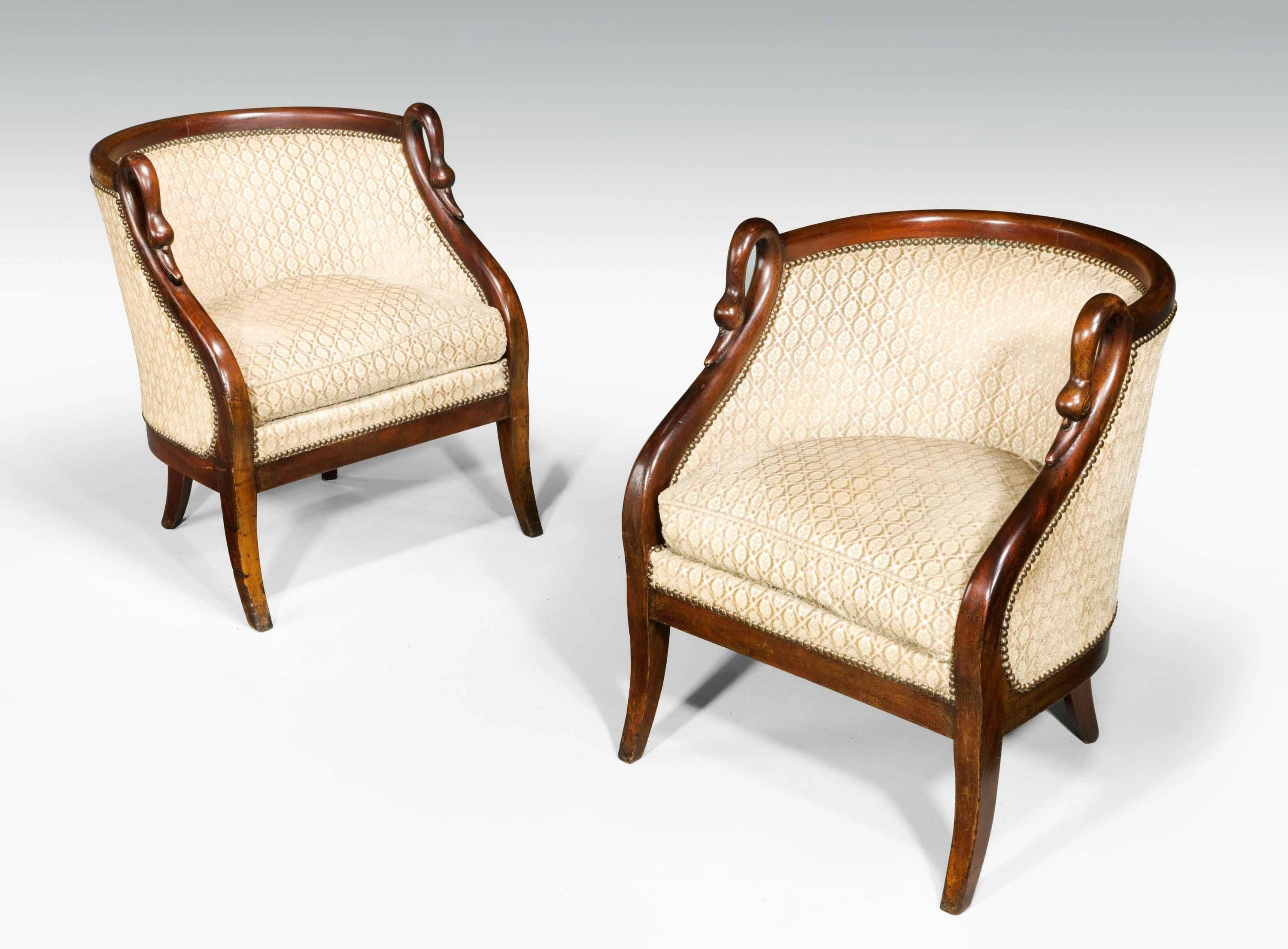 A pair of French mahogany framed armchairs with simulated swans neck uprights, very well figured timber on gentle sabre supports

RR.